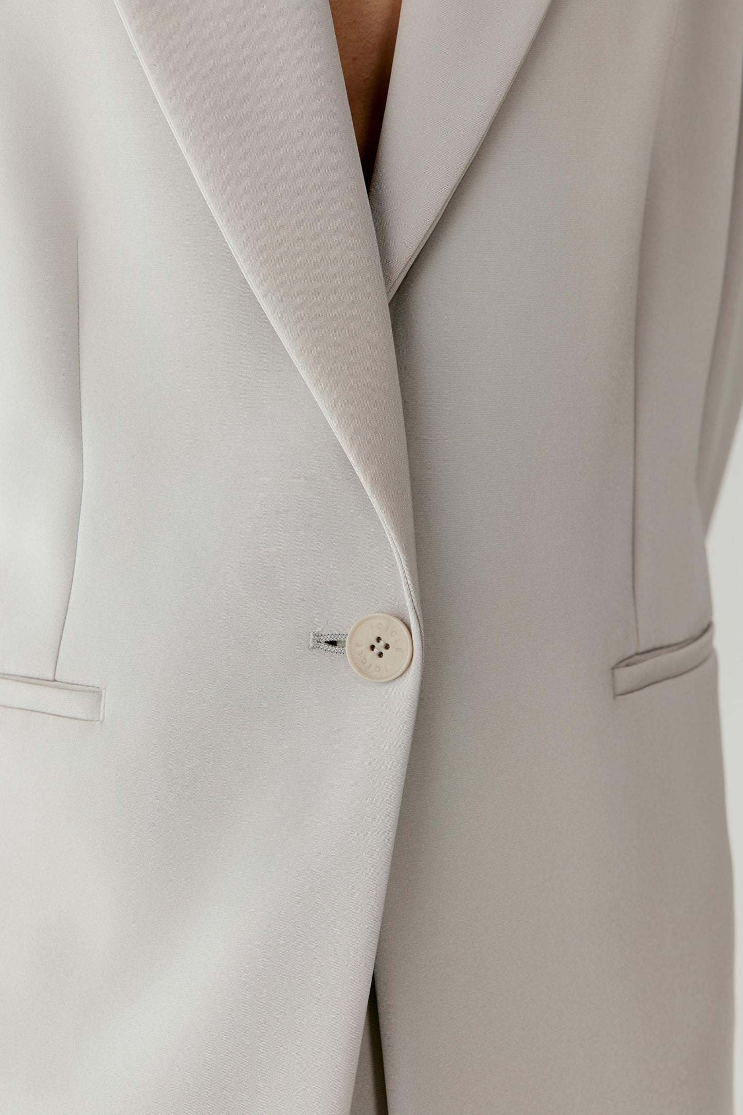 Close-up of the front detailing showing the lapel, button fastening and fine texture of the silk crepe fabric