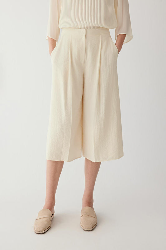 Front or three-quarter view emphasizing the straight silhouette, flat waistband and front pleats, showing the structured fall of the seersucker fabric
