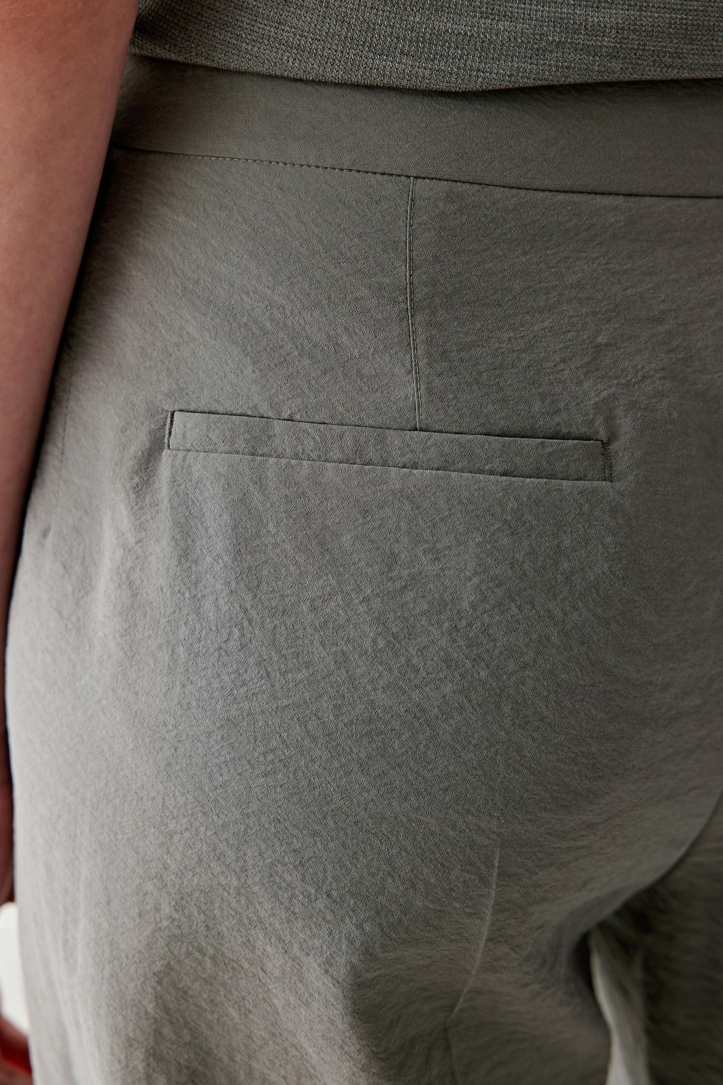 Close-up of pocket and fabric surface showing the lightly puckered texture, visible stitching and tonal depth of the silk nylon blend