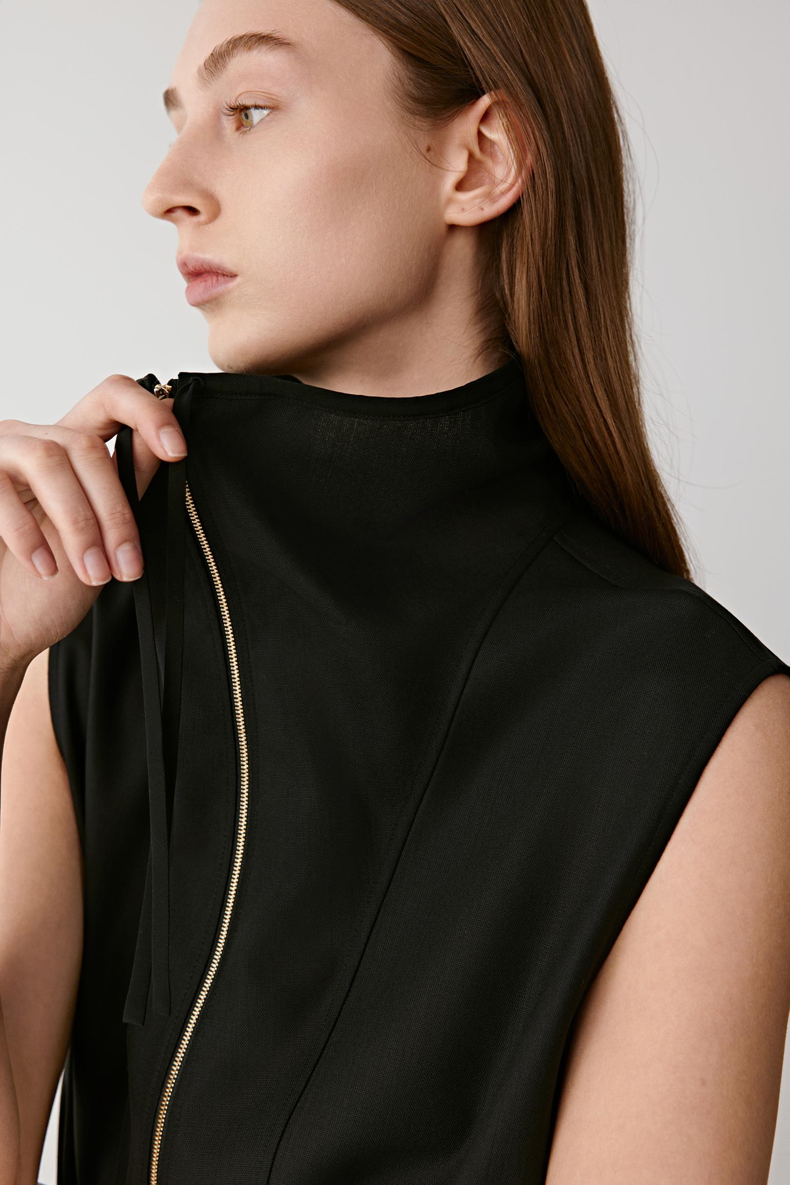 Profile portrait highlighting the high collar and refined finish.