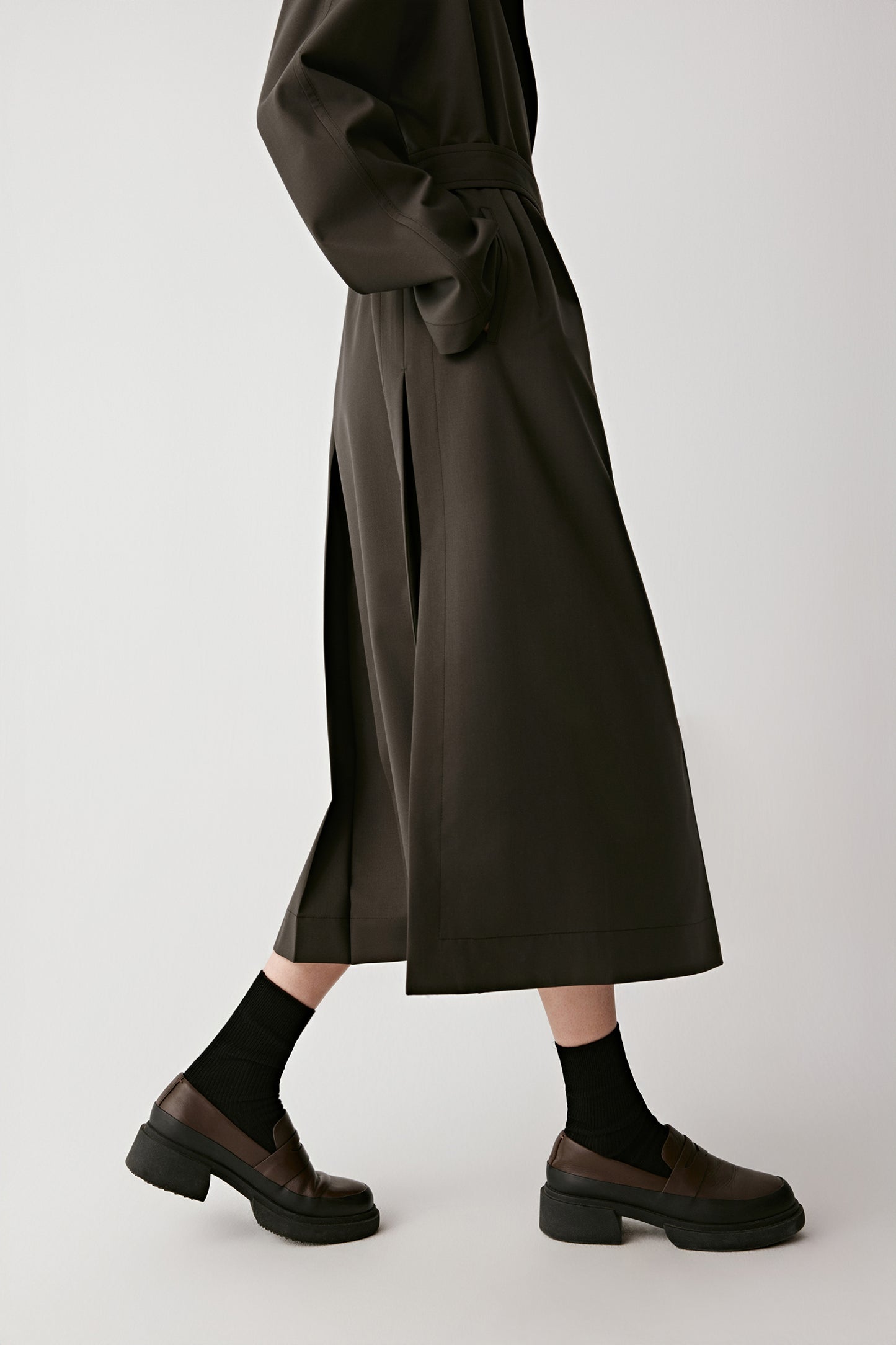 Three-quarter view capturing the minimalist lines and single-breasted front.