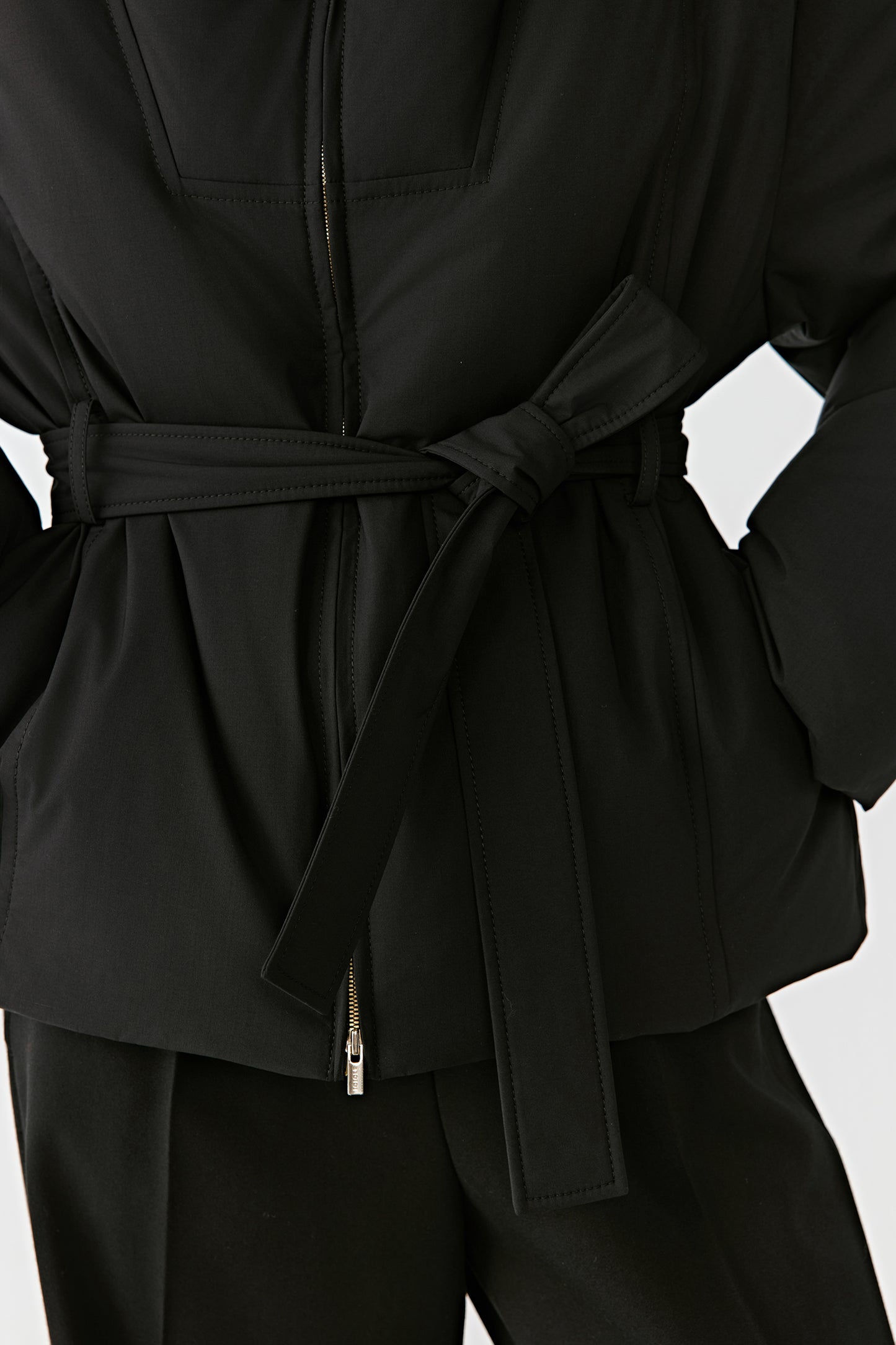 Detail shot of the waist belt and discreet zip fastening at the front.