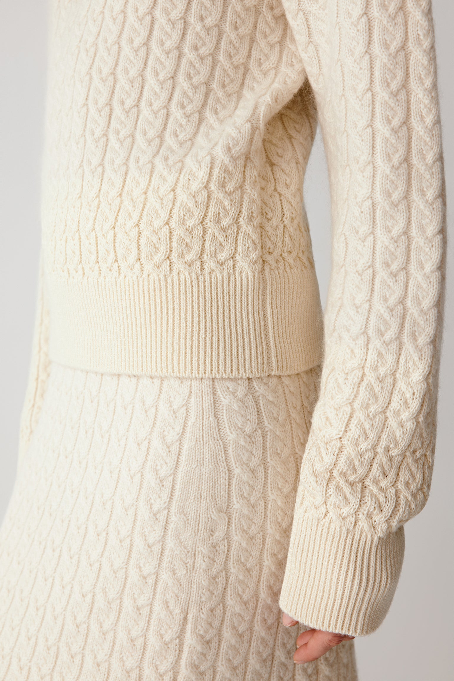 Close-up of the cable-knit texture and ribbed detailing at the edges.