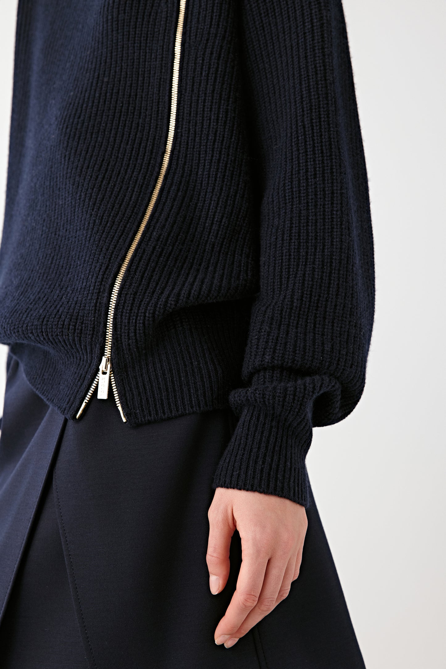 Detail shot of the gold-tone zip placed diagonally across the front.