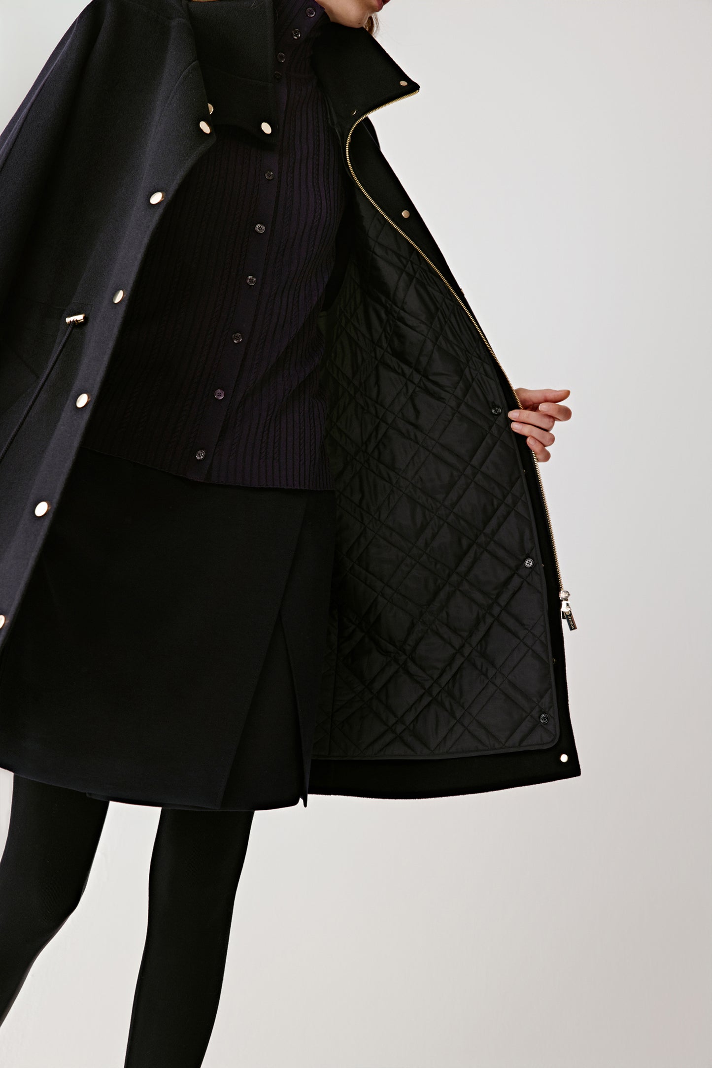 Close-up of the coat’s removable quilted lining and gold-tone button details.