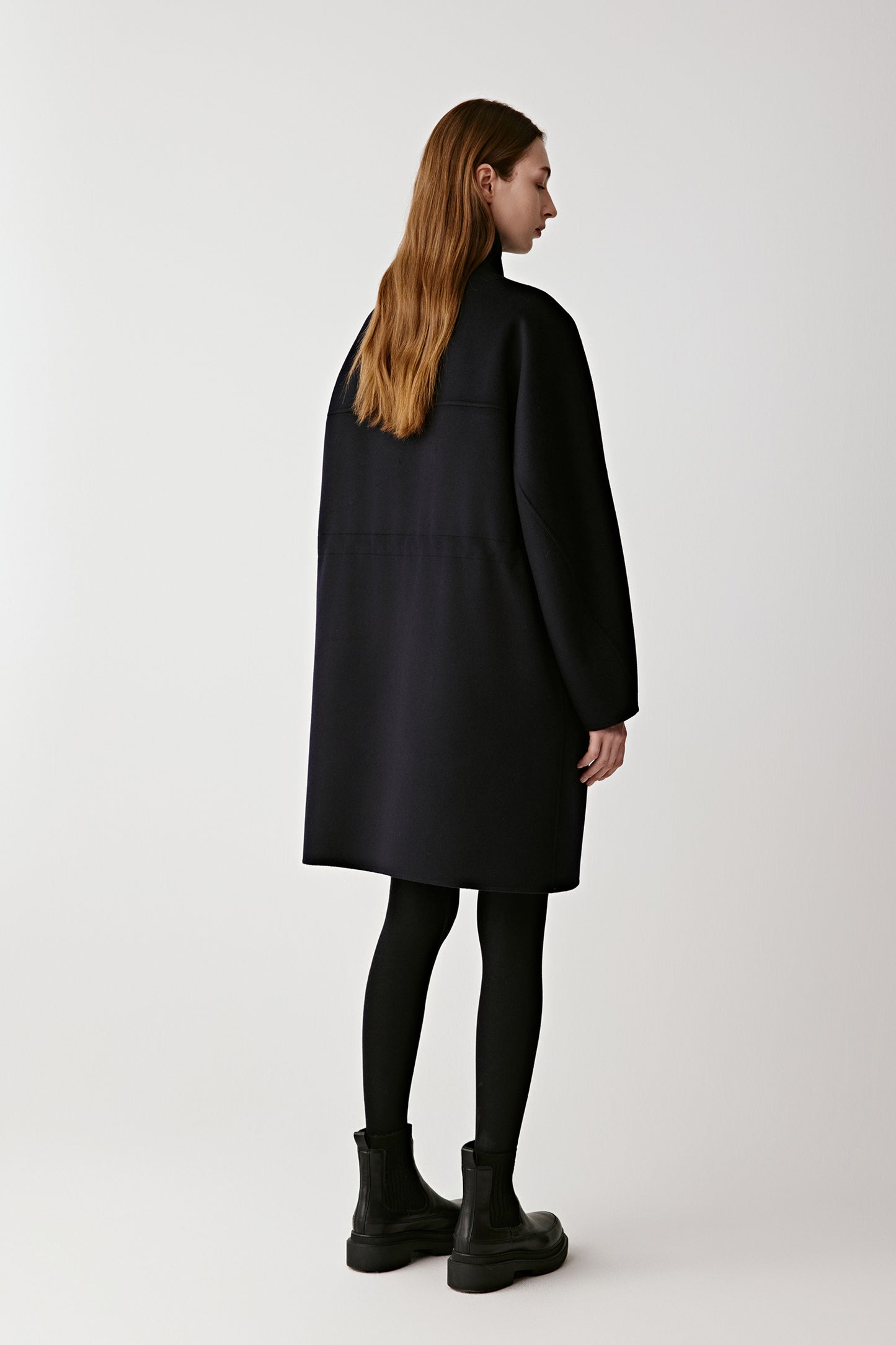 Back view showing the coat’s elegant drape and clean silhouette.