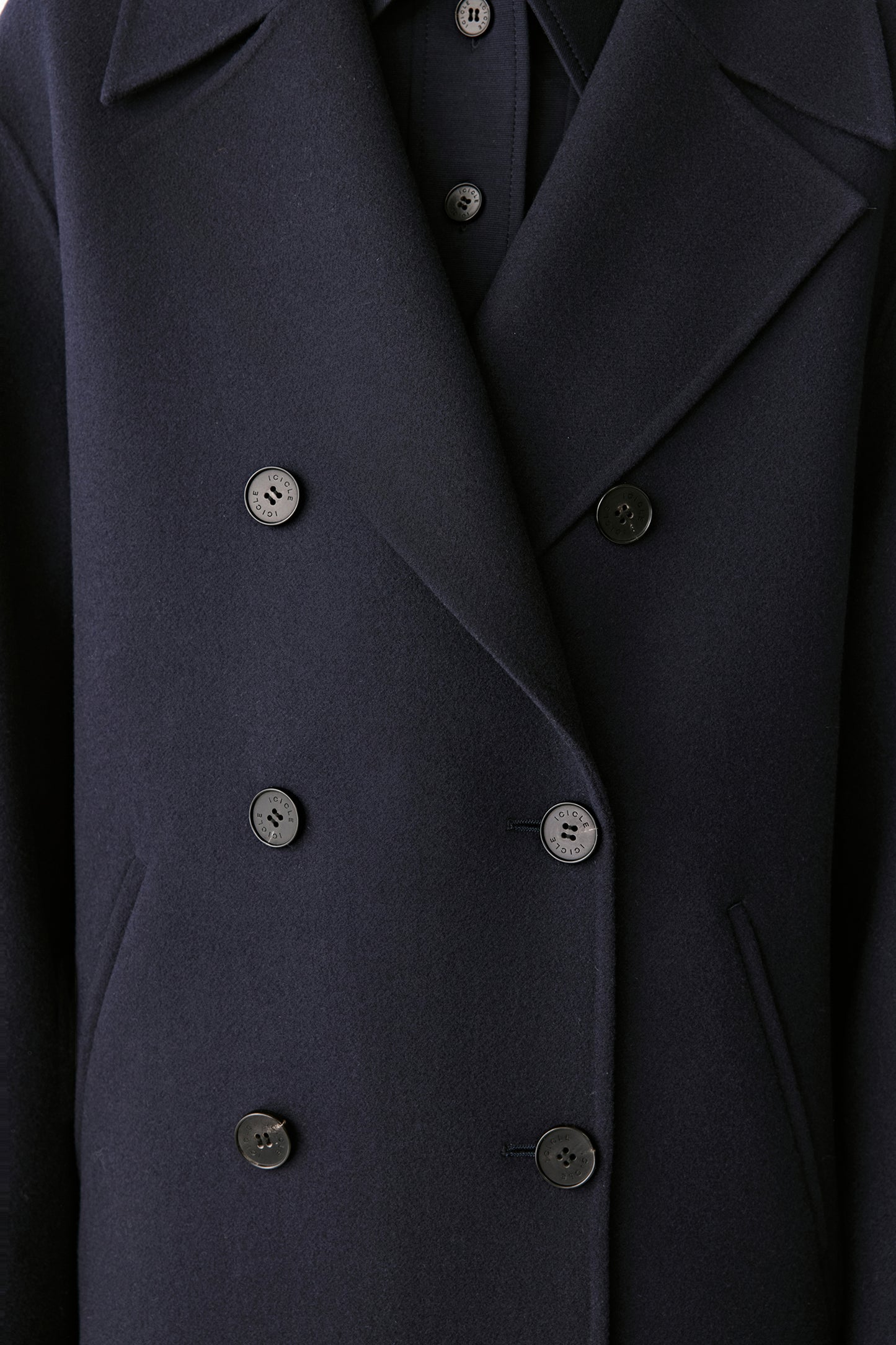 Close-up of the gold-tone buttons and double-faced fabric texture.