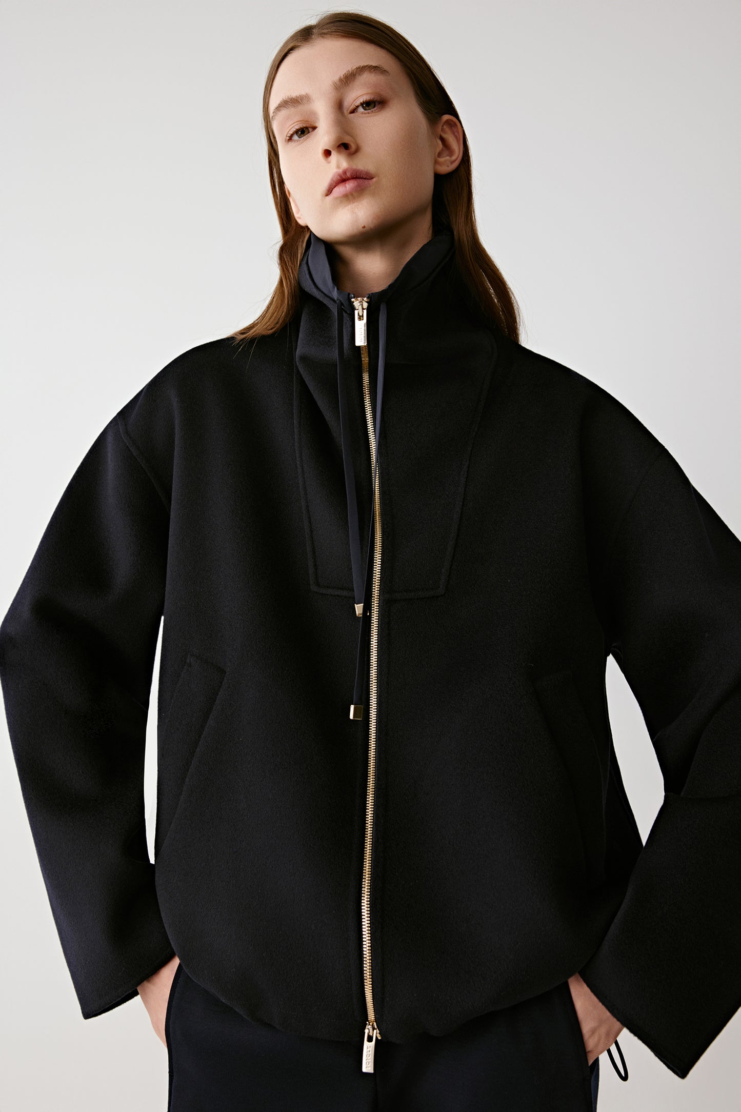 Three-quarter view highlighting the adjustable drawcord collar and slanted side pockets.