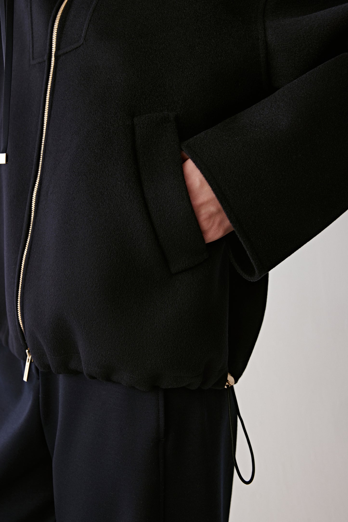 Detail shot of the hem and side vent, emphasizing the smooth double-faced texture.