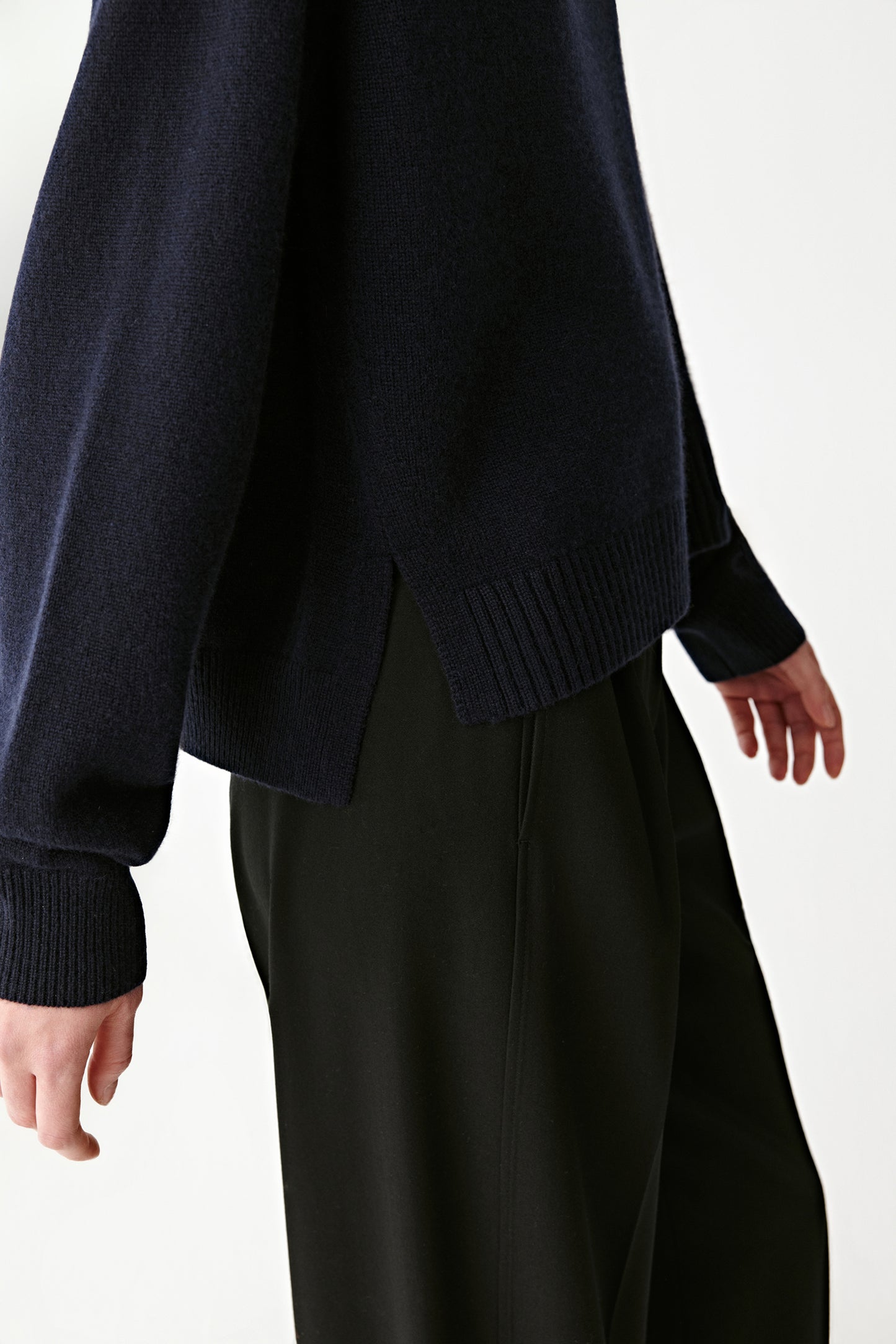 Close-up of the sleeve and collar showing the fine ribbed texture and natural sheen of the cashmere.