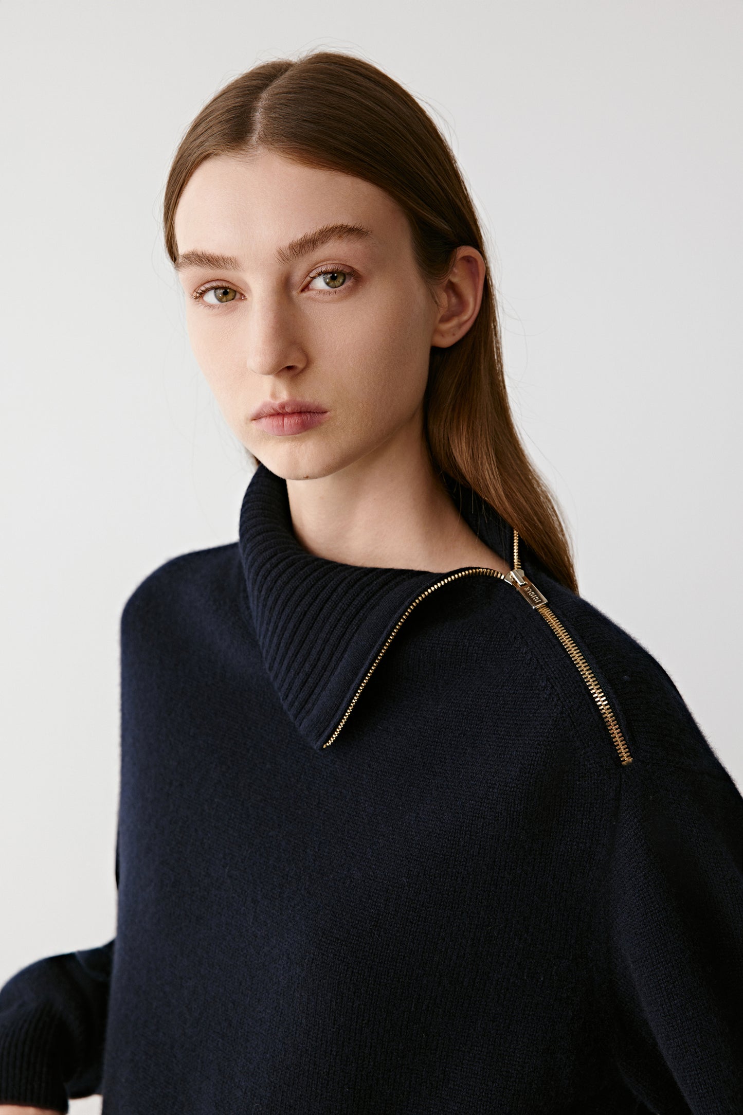 Three-quarter back view capturing the layered hem and soft silhouette of the jumper.
