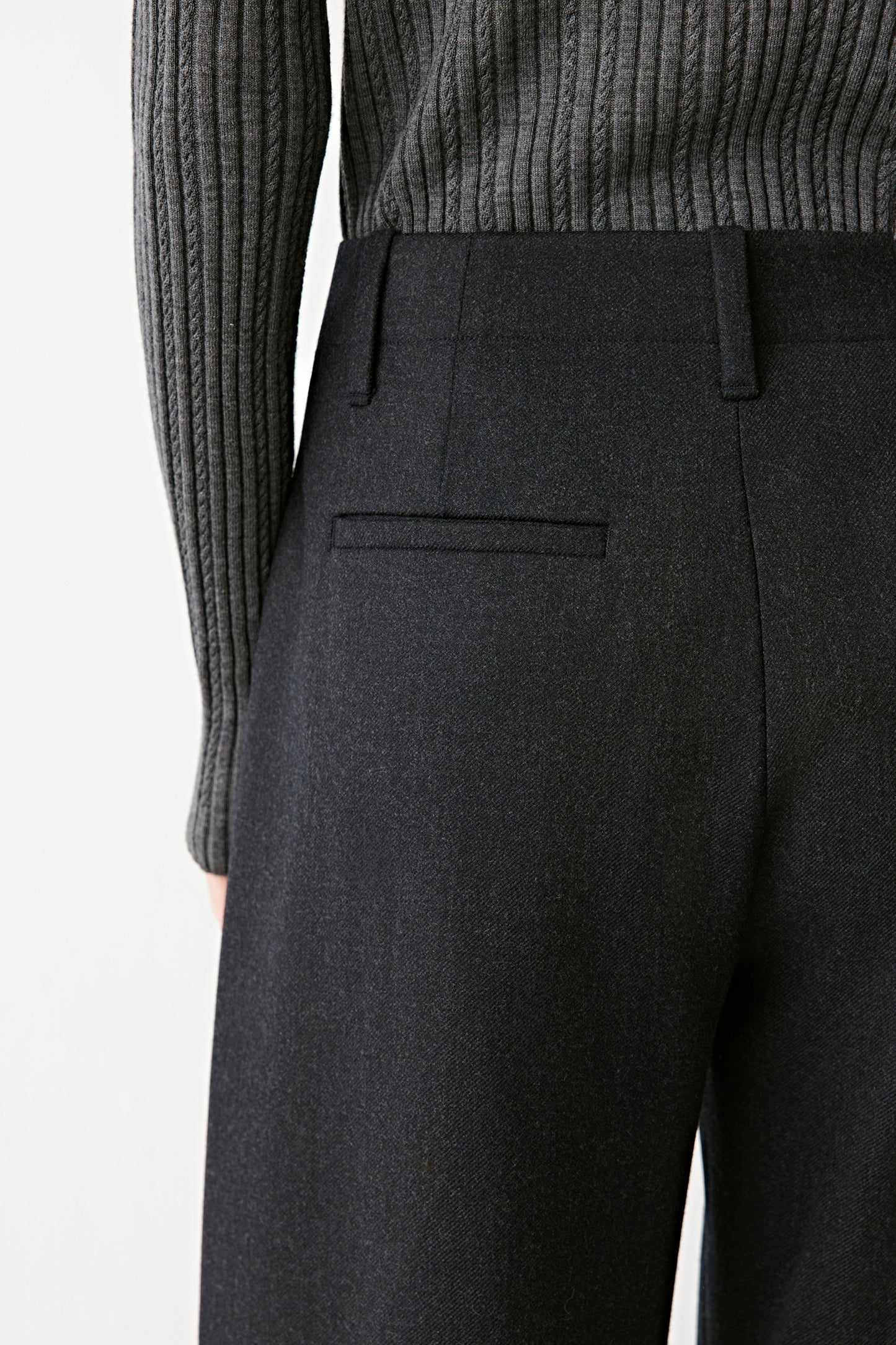 Close-up of the back welt pocket and fine texture of the wool fabric.