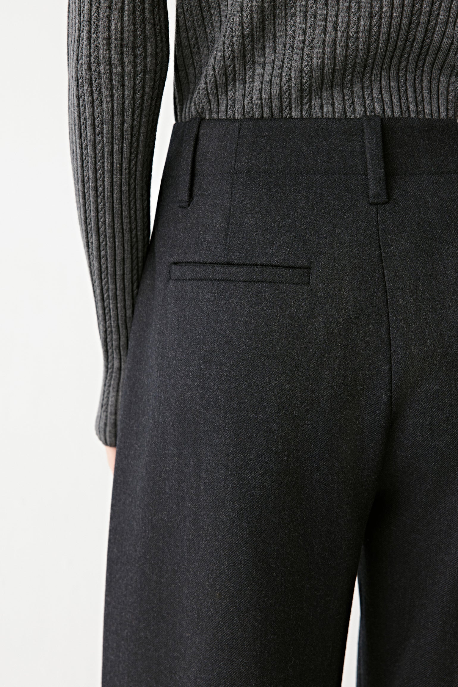 Close-up of the back welt pocket and fine texture of the wool fabric.