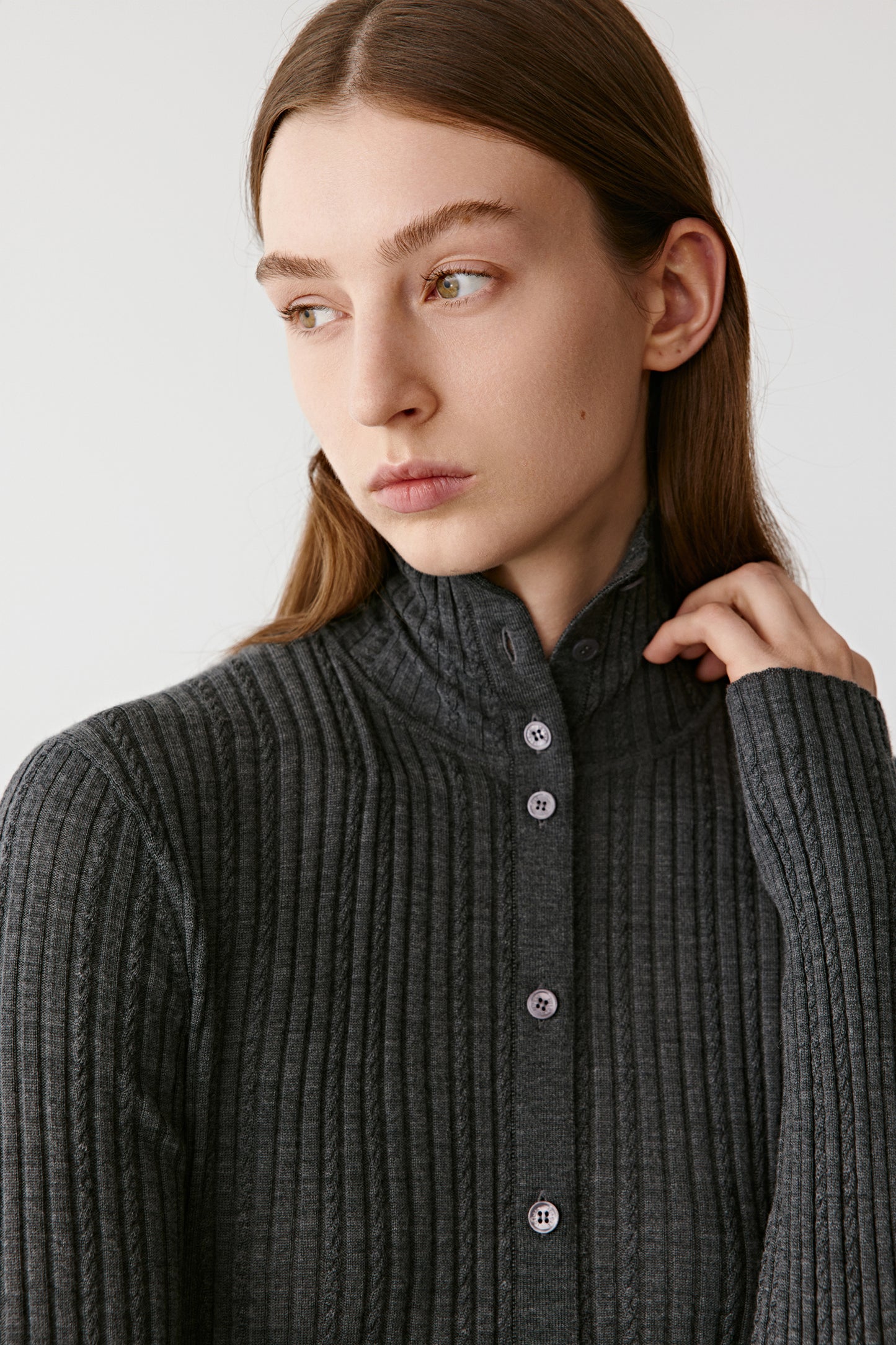 Close-up portrait of the model showing the high collar and button details.