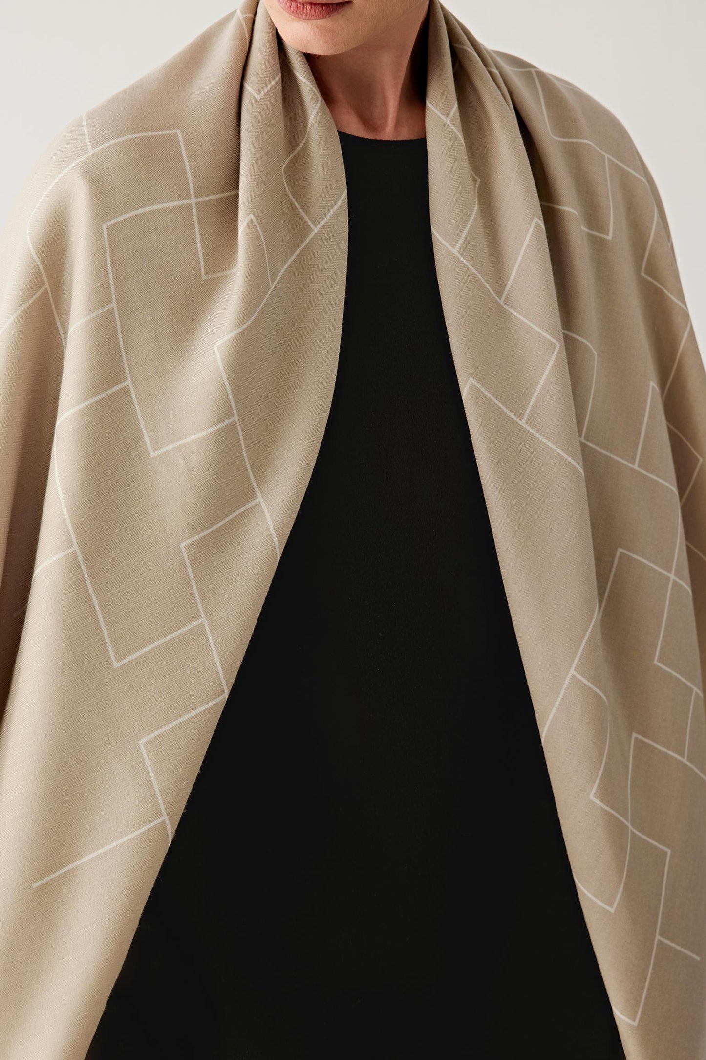 Close-up view of the scarf around the neckline, showing the delicate weave, refined finish, and natural sheen of the fabric.