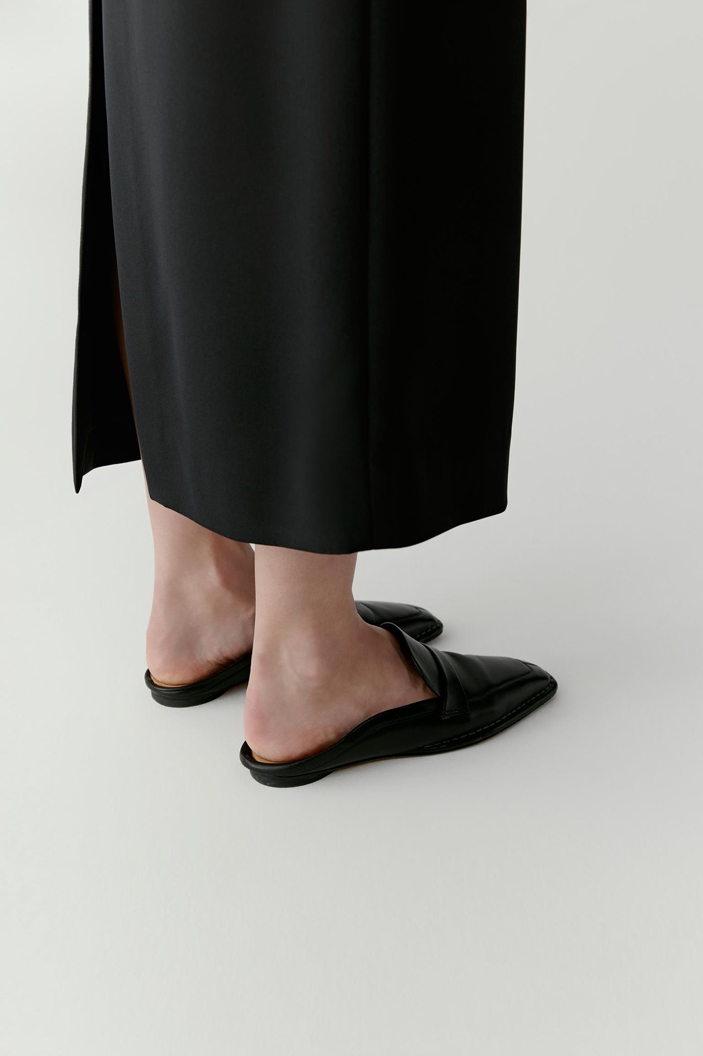 Back view highlighting the slip-on design and the slim sole that reinforces the minimal aesthetic.
