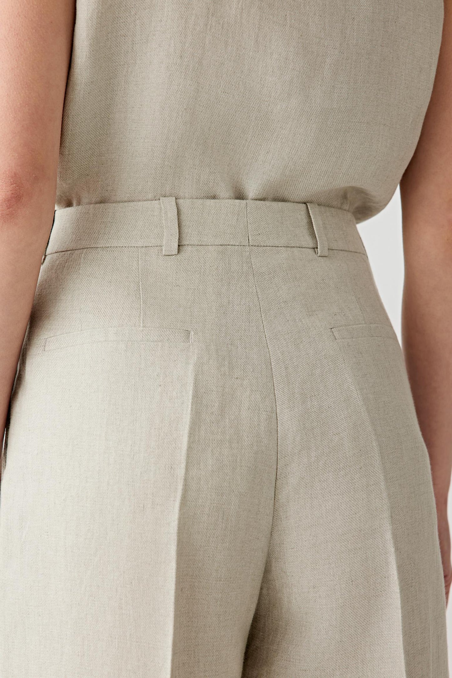 Close-up of the fabric and pocket detailing showing the visible grain, dry texture and subtle tonal irregularities characteristic of linen twill.