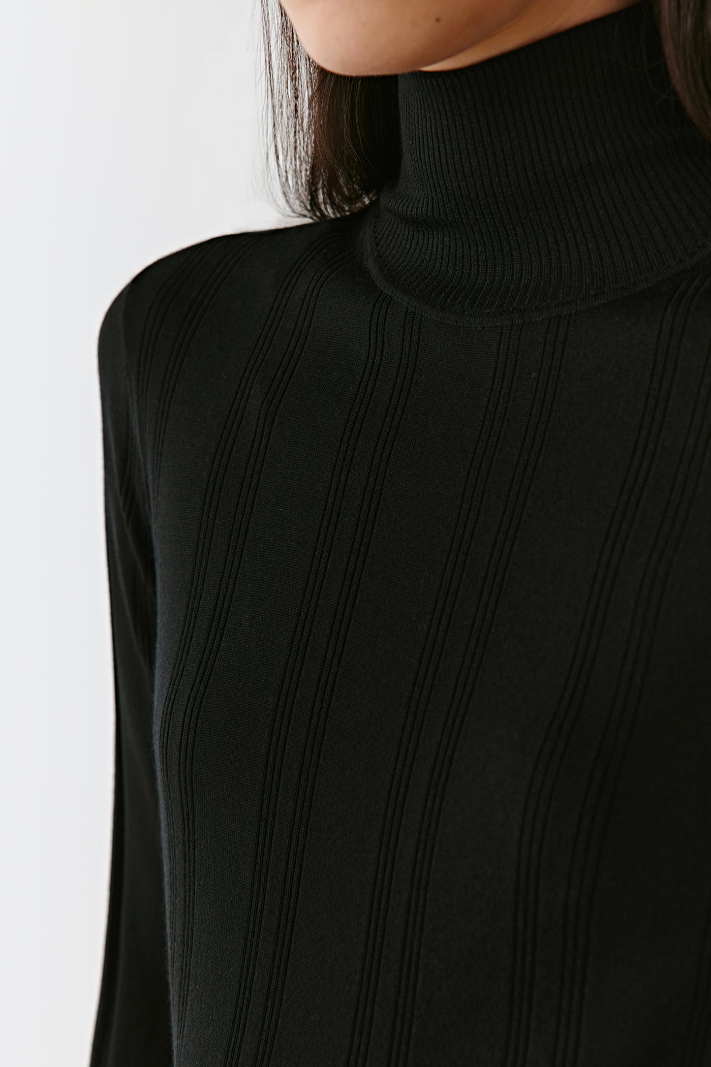 A mid-shot focuses on the neckline and the refined finish at the wrists.