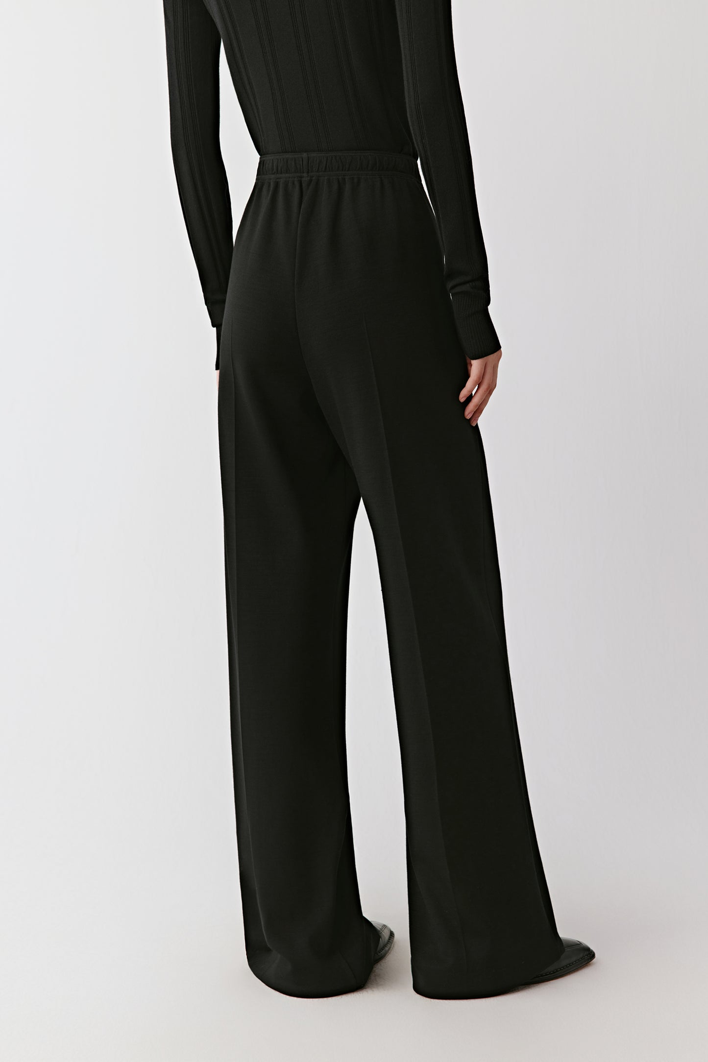 A rear view highlights the straight line of the cut and smooth elasticated waistband.