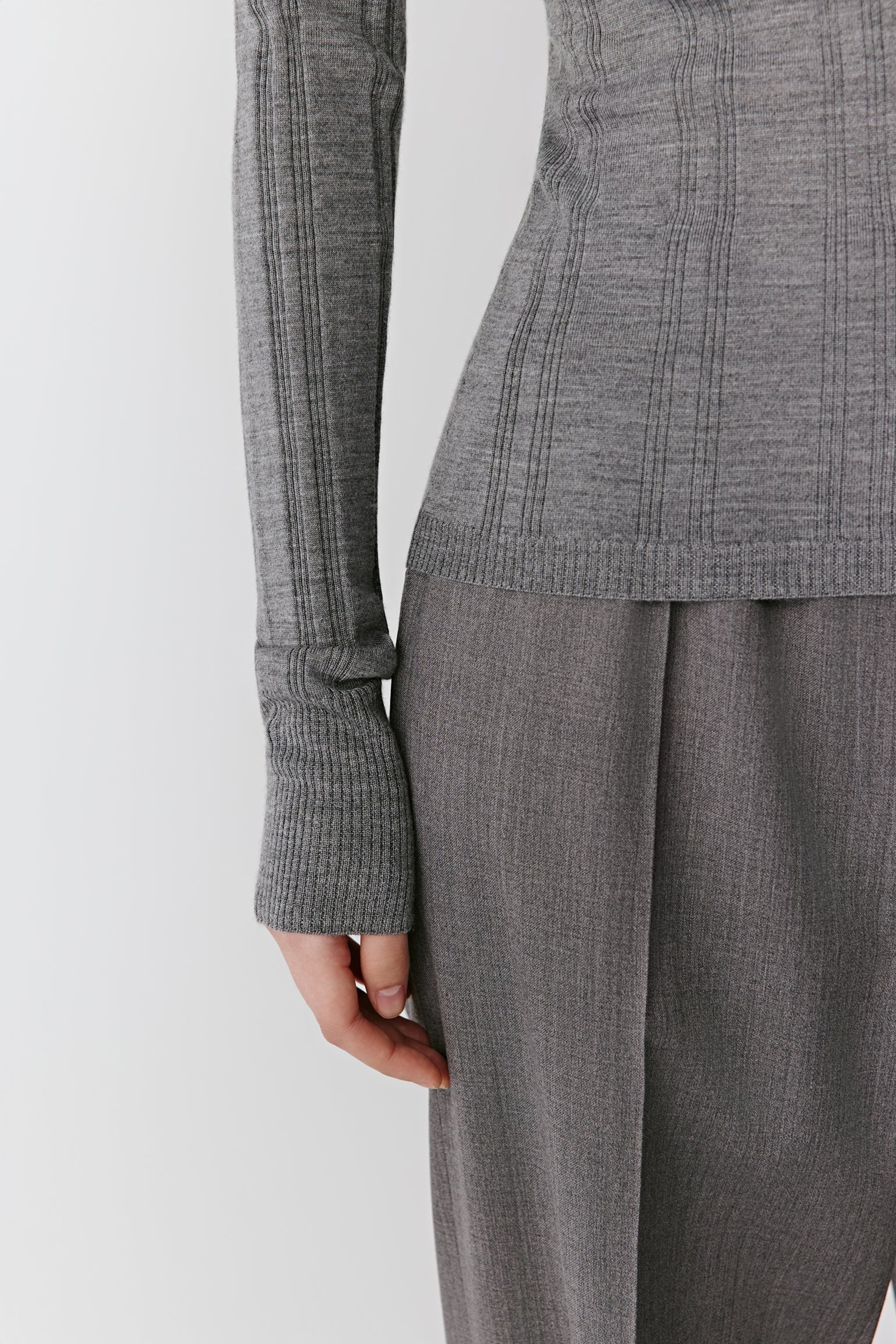A close-up reveals the fine ribbing and lustrous finish of the fabric.
