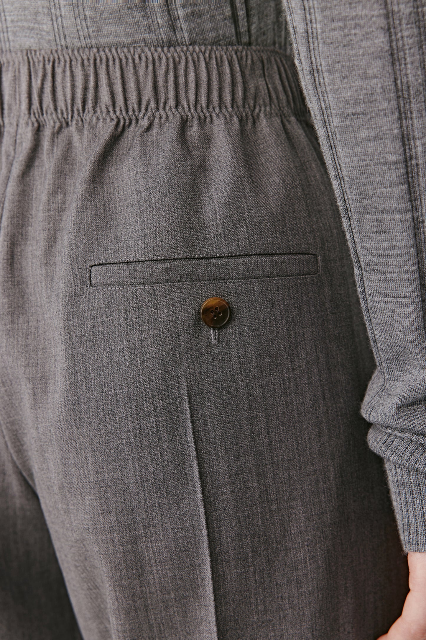 Macro shot showing the refined weave and natural sheen of the worsted wool fabric.