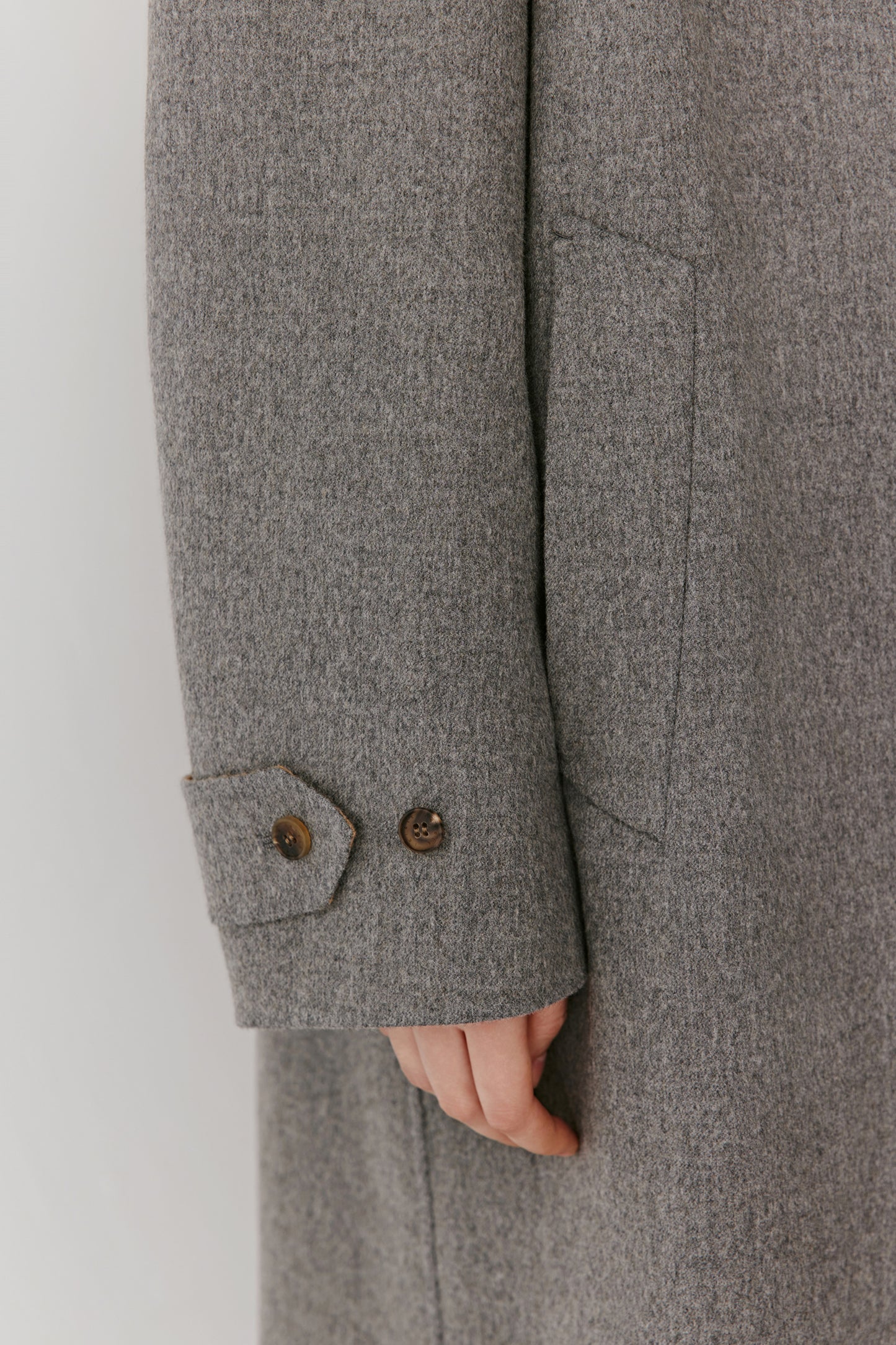 A closer look at the symmetrical welt pockets and subtle melange tone of the fabric.