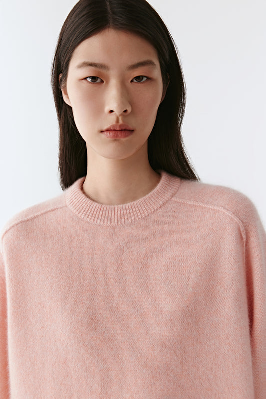 Portrait view highlighting the crew neck and gentle texture of the natural cashmere fibre.