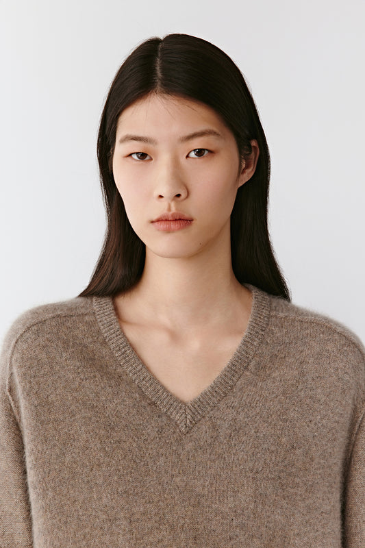 Portrait view highlighting the V-neckline and soft, brushed texture of the cashmere.