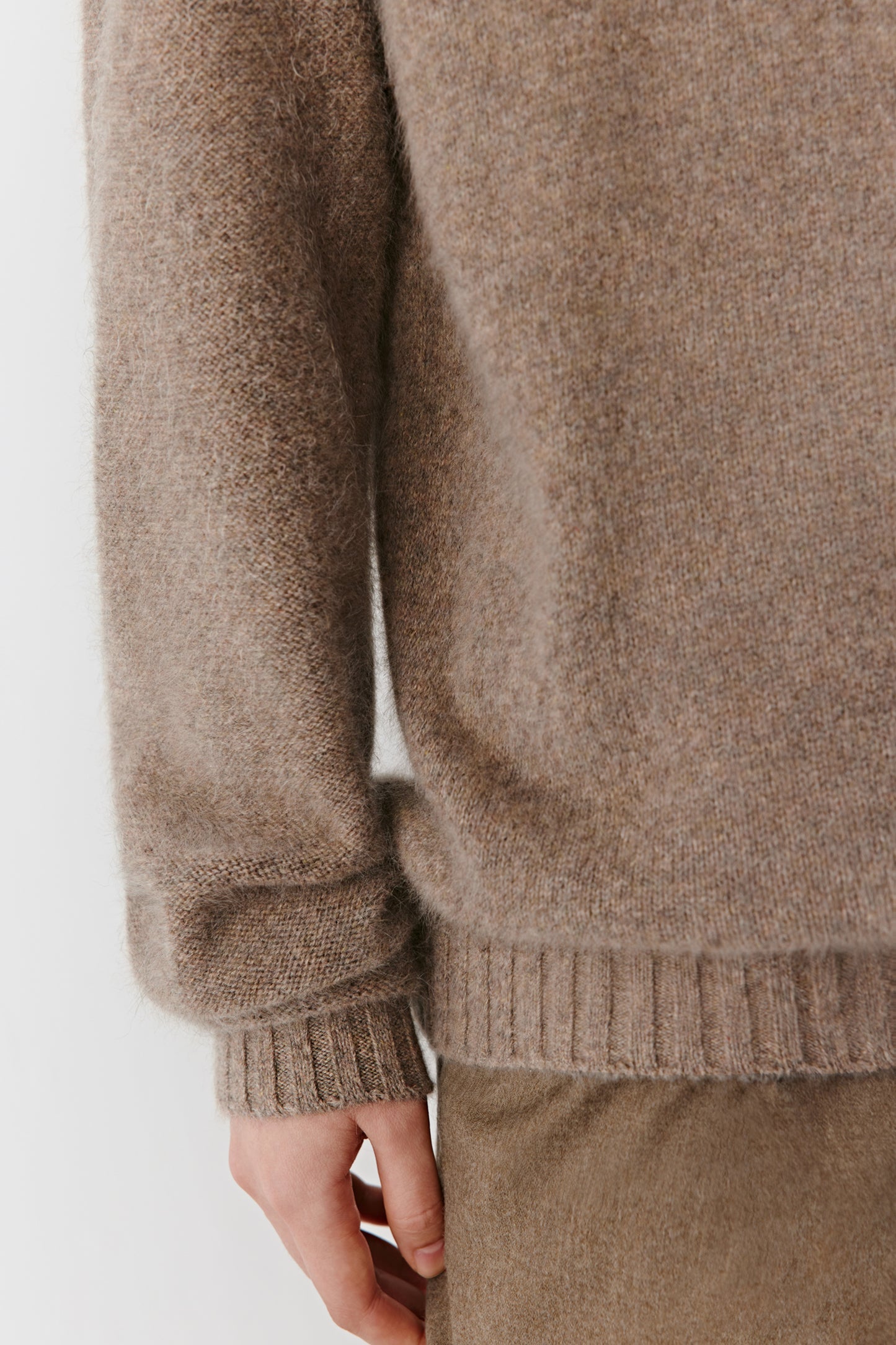 Close-up of the sleeve and hem showing the fine ribbed detailing and subtle mélange tone.