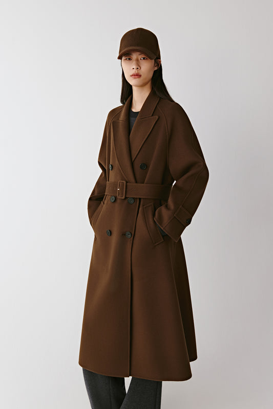 Three-quarter front view highlighting the double-breasted closure, notched lapels, and covered belt buckle.