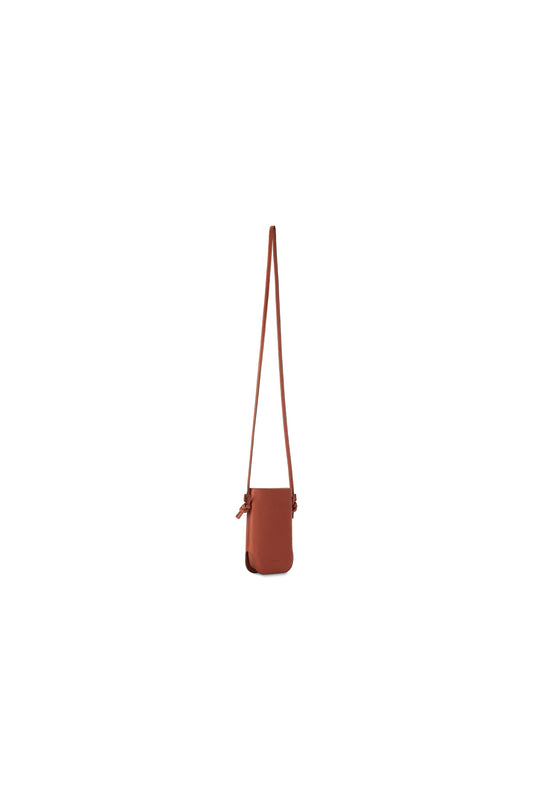 Side view of the brown leather shoulder bag showing its slim silhouette and long strap.