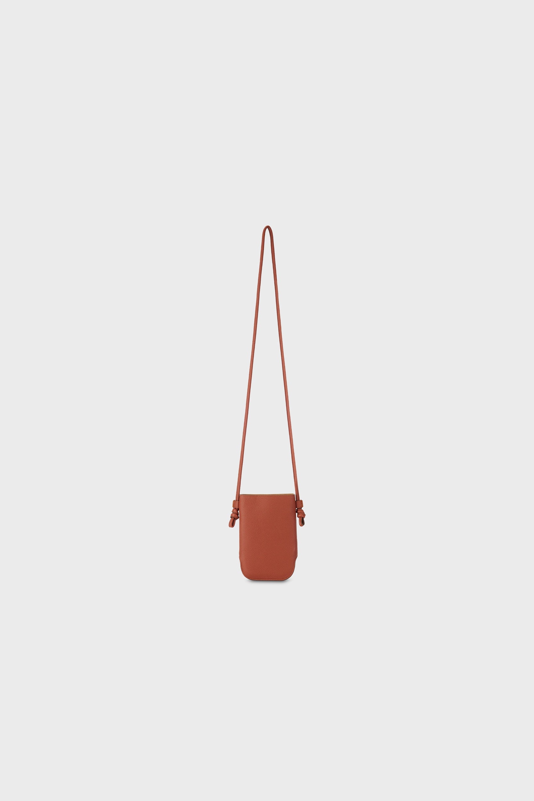 Front view of a brown leather shoulder bag with a long strap, photographed on a neutral background.