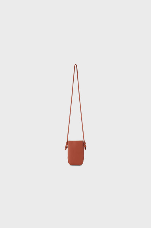 Front view of a brown leather shoulder bag with a long strap, photographed on a neutral background.