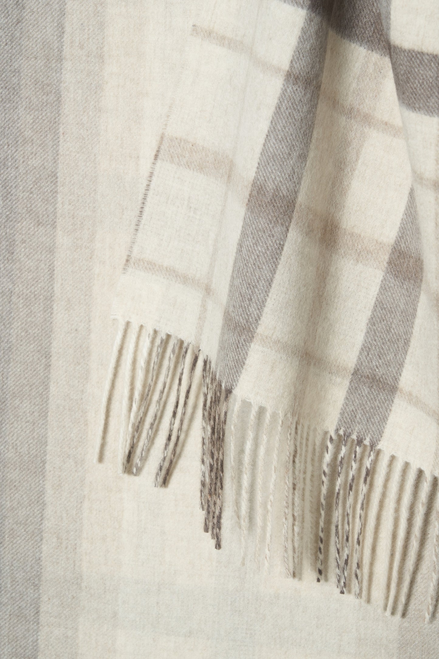 Close-up of a checkered scarf with fringes on a light background