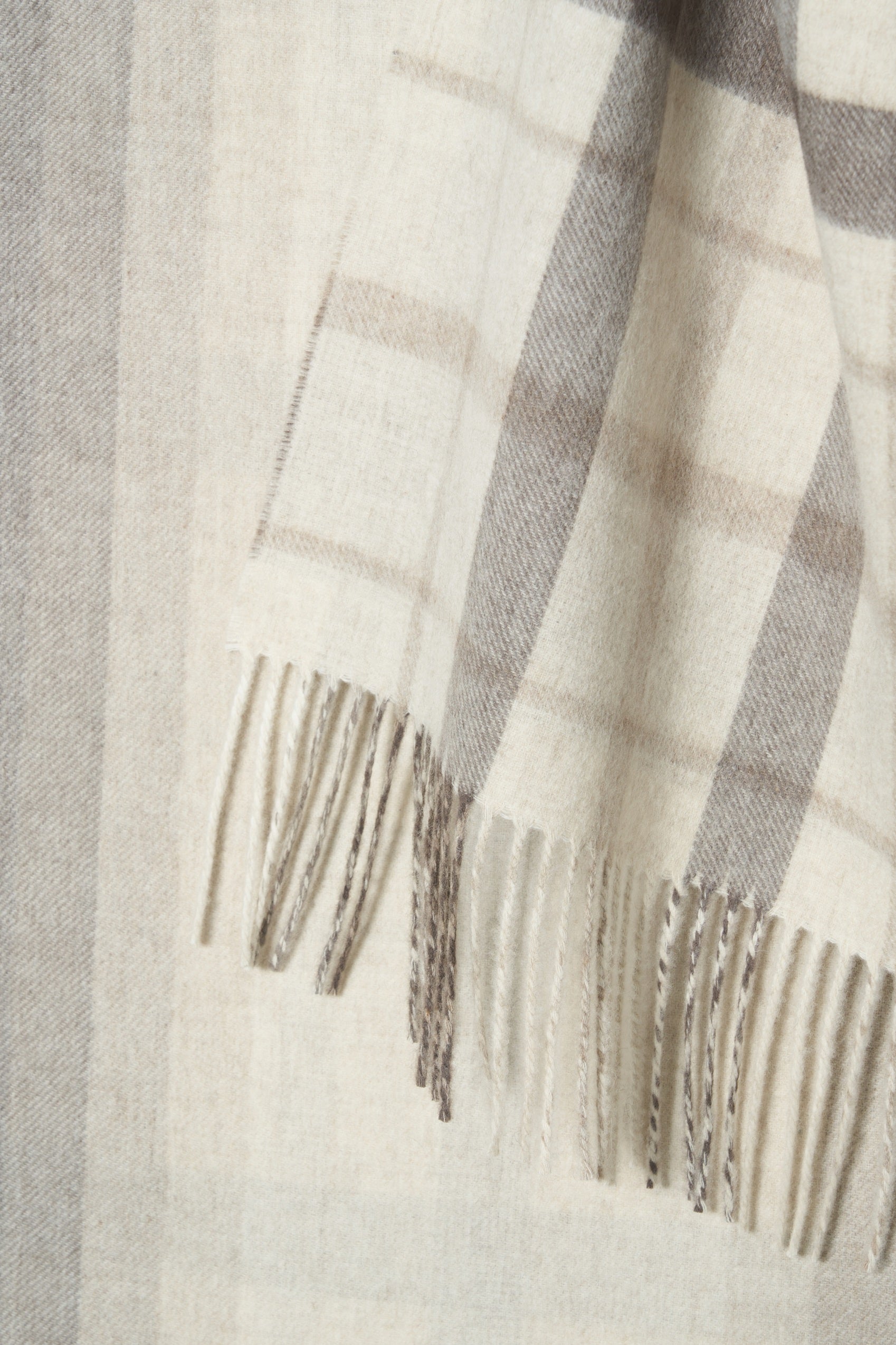 Close-up of a checkered scarf with fringes on a light background