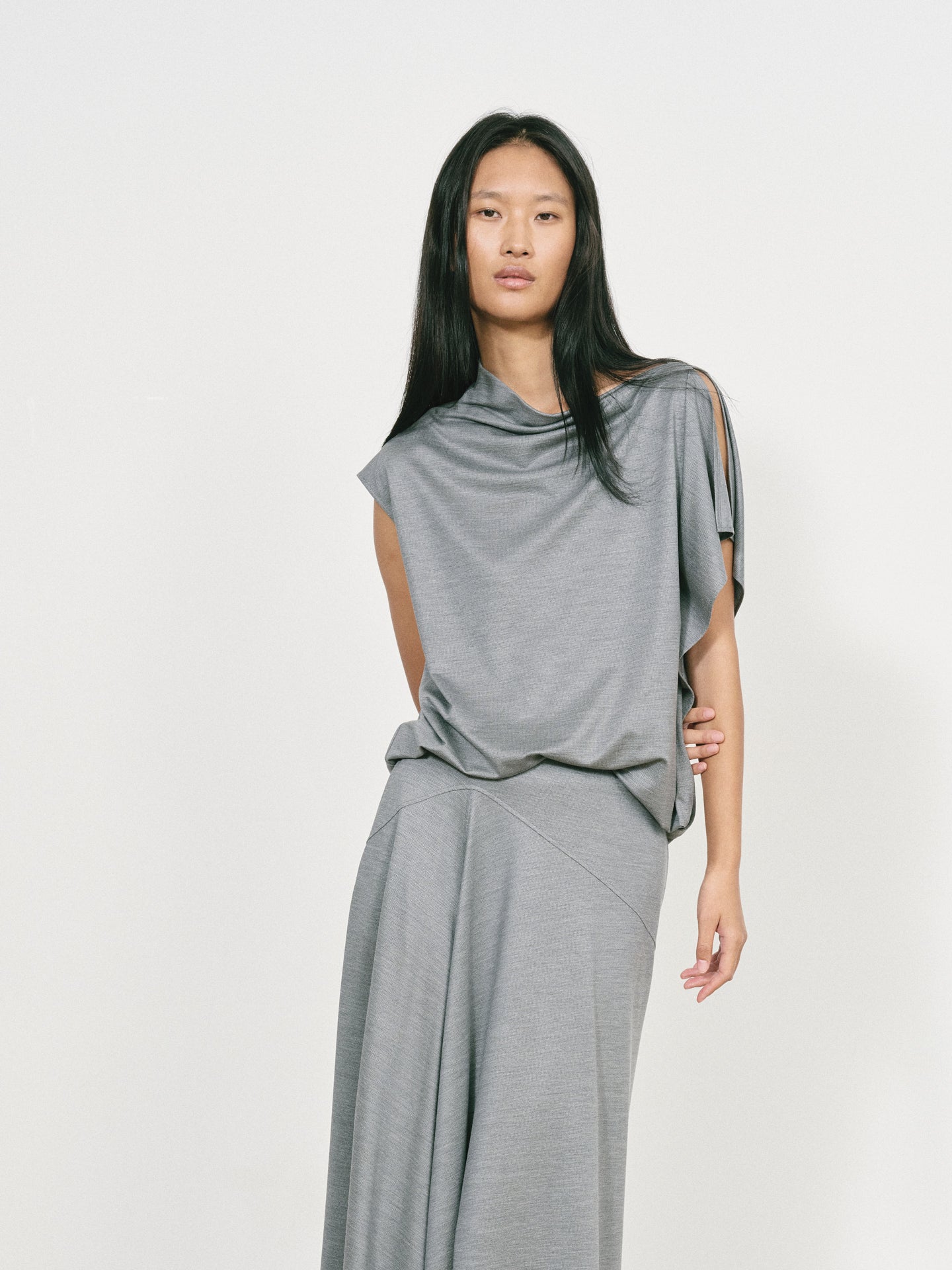 Woman wearing a gray dress against a white background