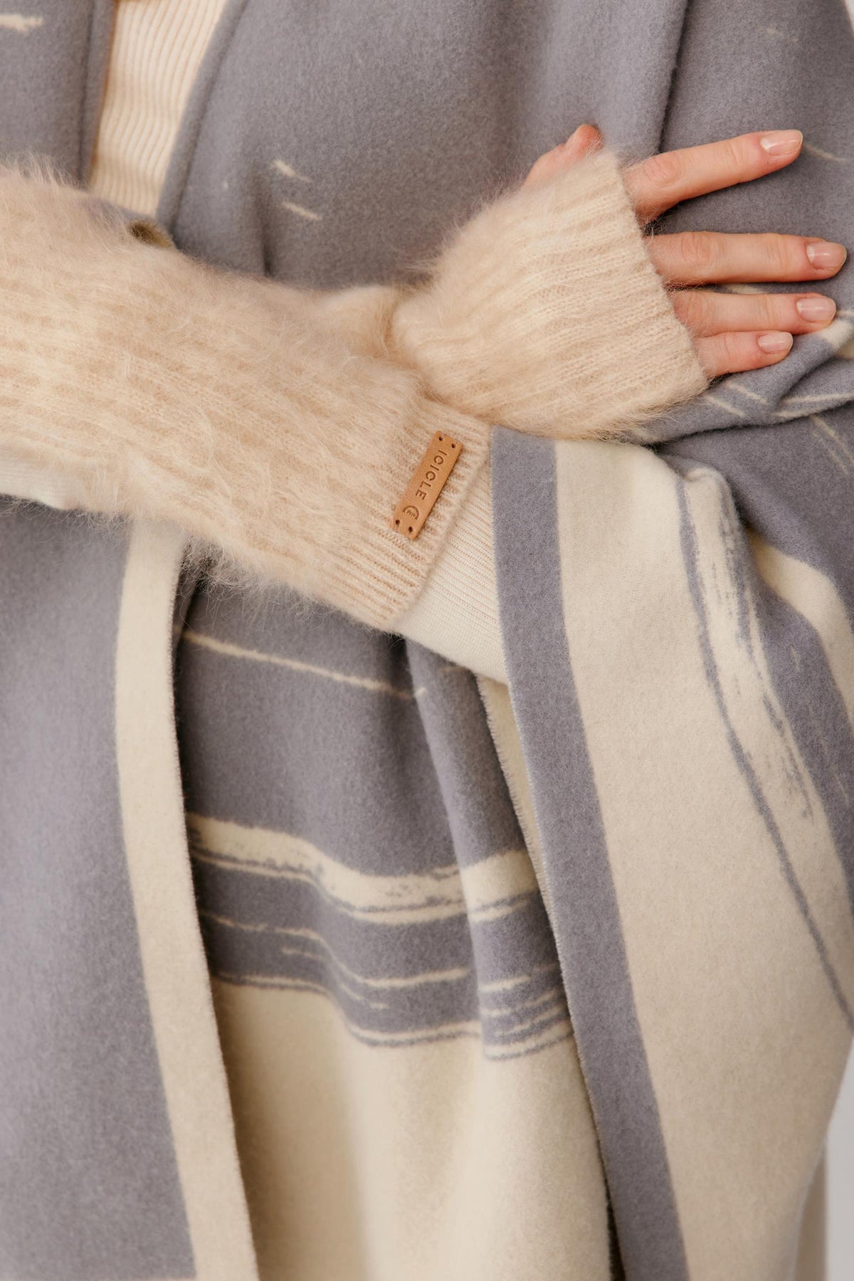 Close-up highlighting the natural beige brushed cashmere fingerless glove, ribbed knit texture and open-finger construction.