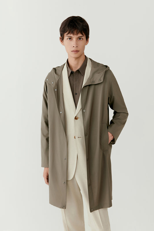 Front view showing the coat worn slightly open, revealing the clean placket and simple lines.