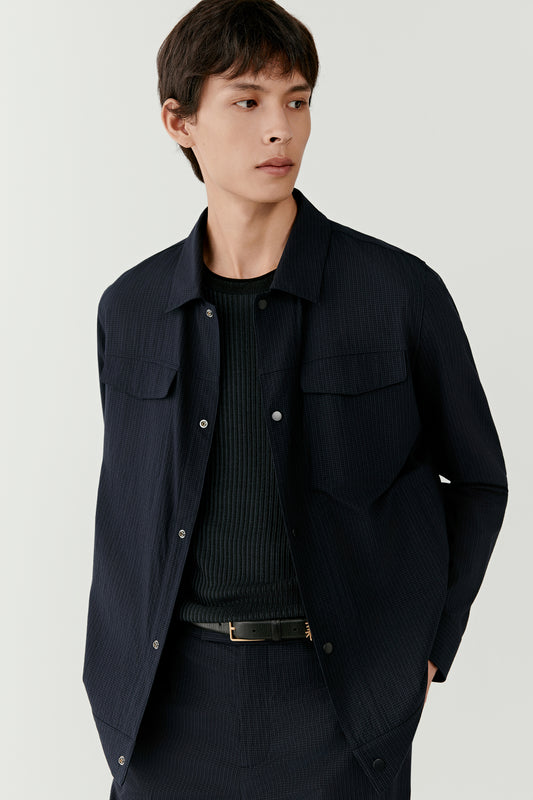 Three-quarter view showing the minimalist snap-button placket and clean tailoring.
