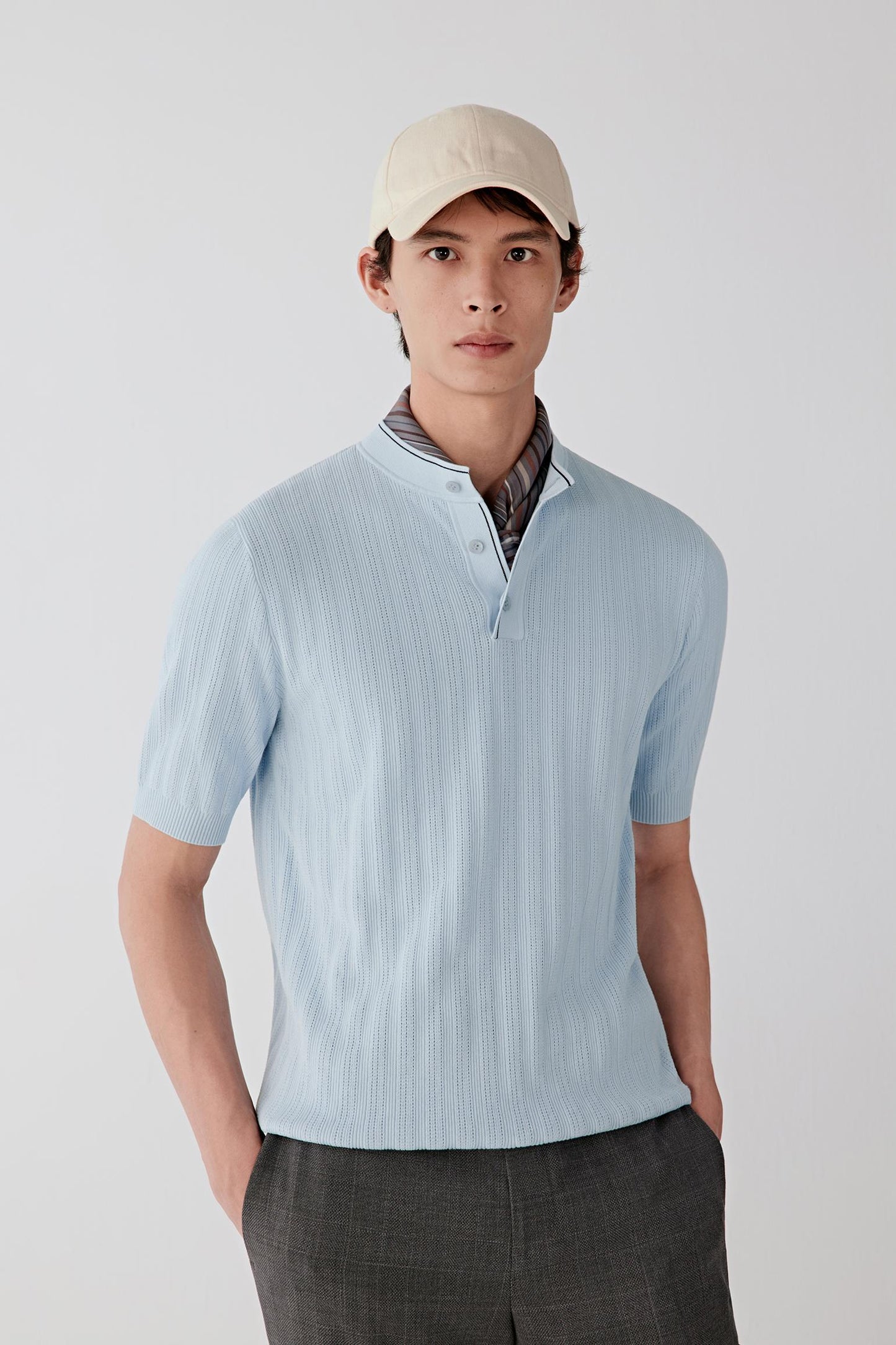 Front view of a light blue cotton-yarn pullover with short button placket and relaxed fit.