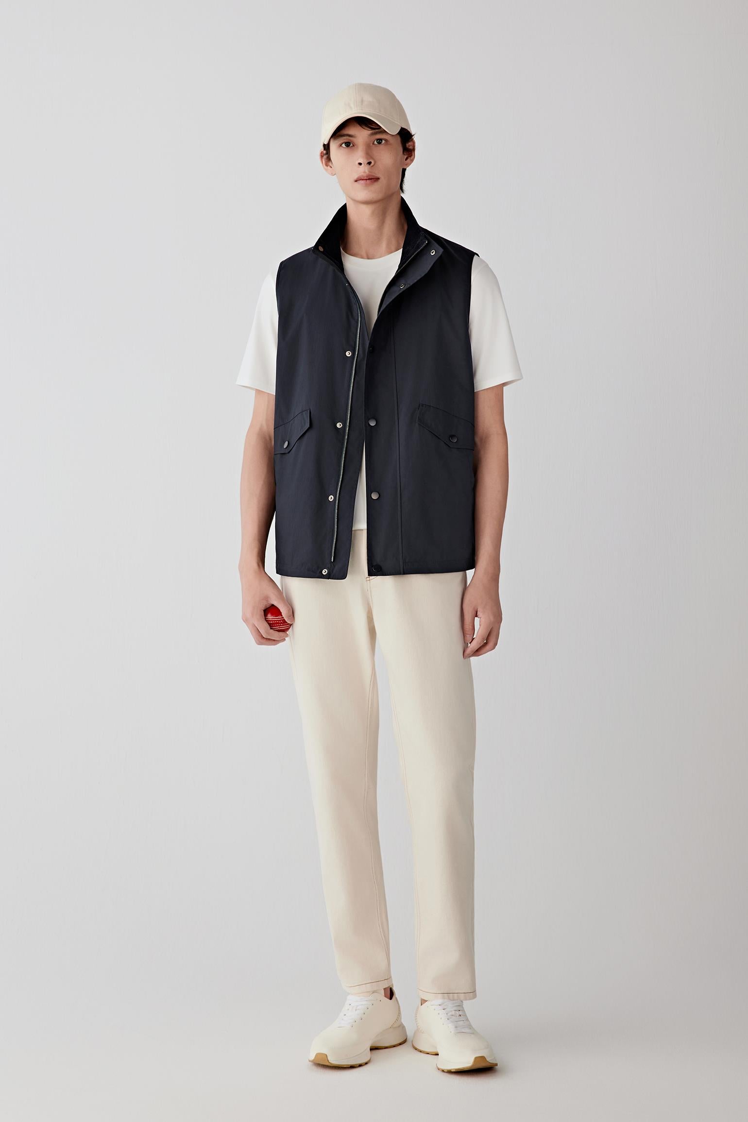 Front view of a sleeveless cotton poplin vest worn open, showing a clean, layered look.