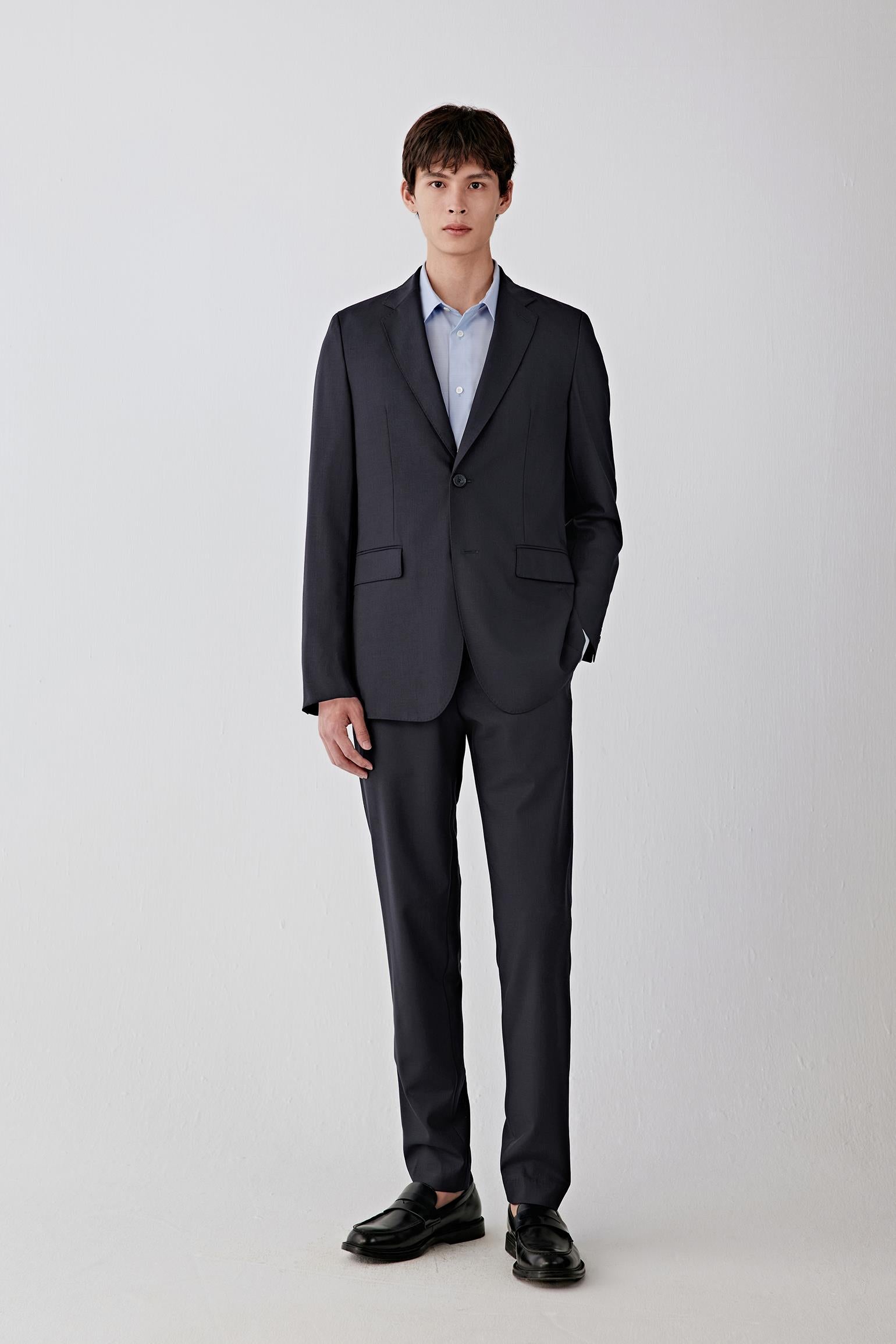 Full-length front view highlighting the single-breasted closure, straight silhouette and even fall from shoulder to hem, creating a sharp, elongated line.