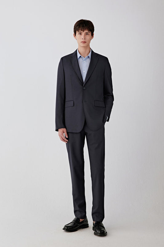 Full-length front view highlighting the single-breasted closure, straight silhouette and even fall from shoulder to hem, creating a sharp, elongated line.