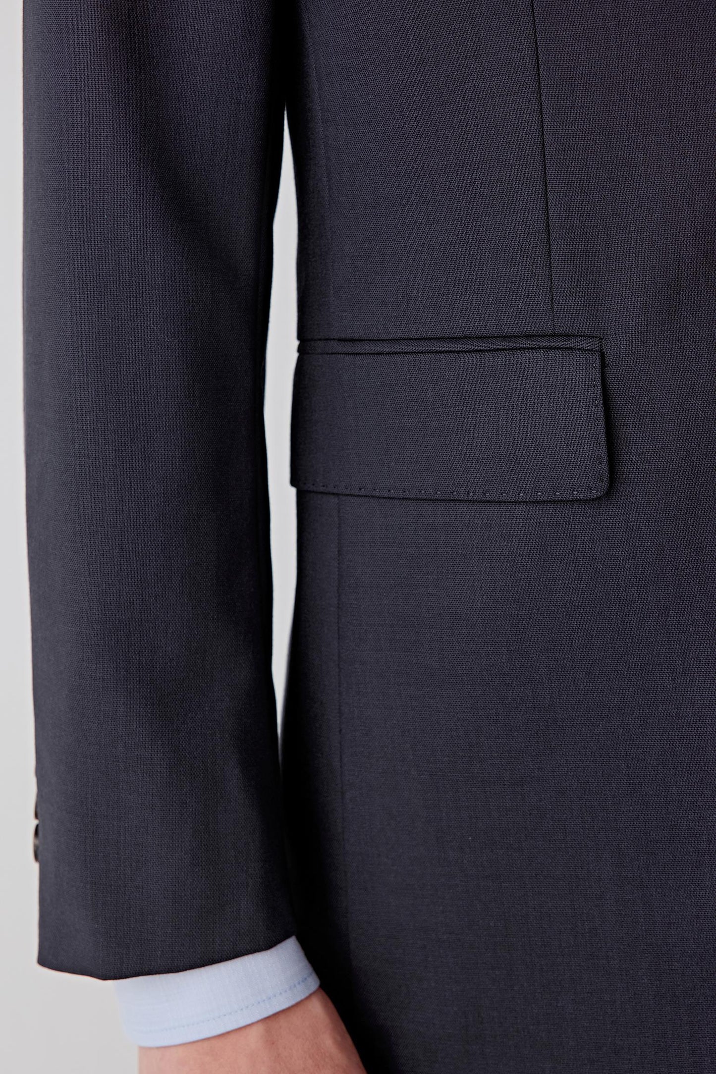 Detail of the sleeve and cuff, highlighting the clean seam construction, straight sleeve line and compact fabric structure.