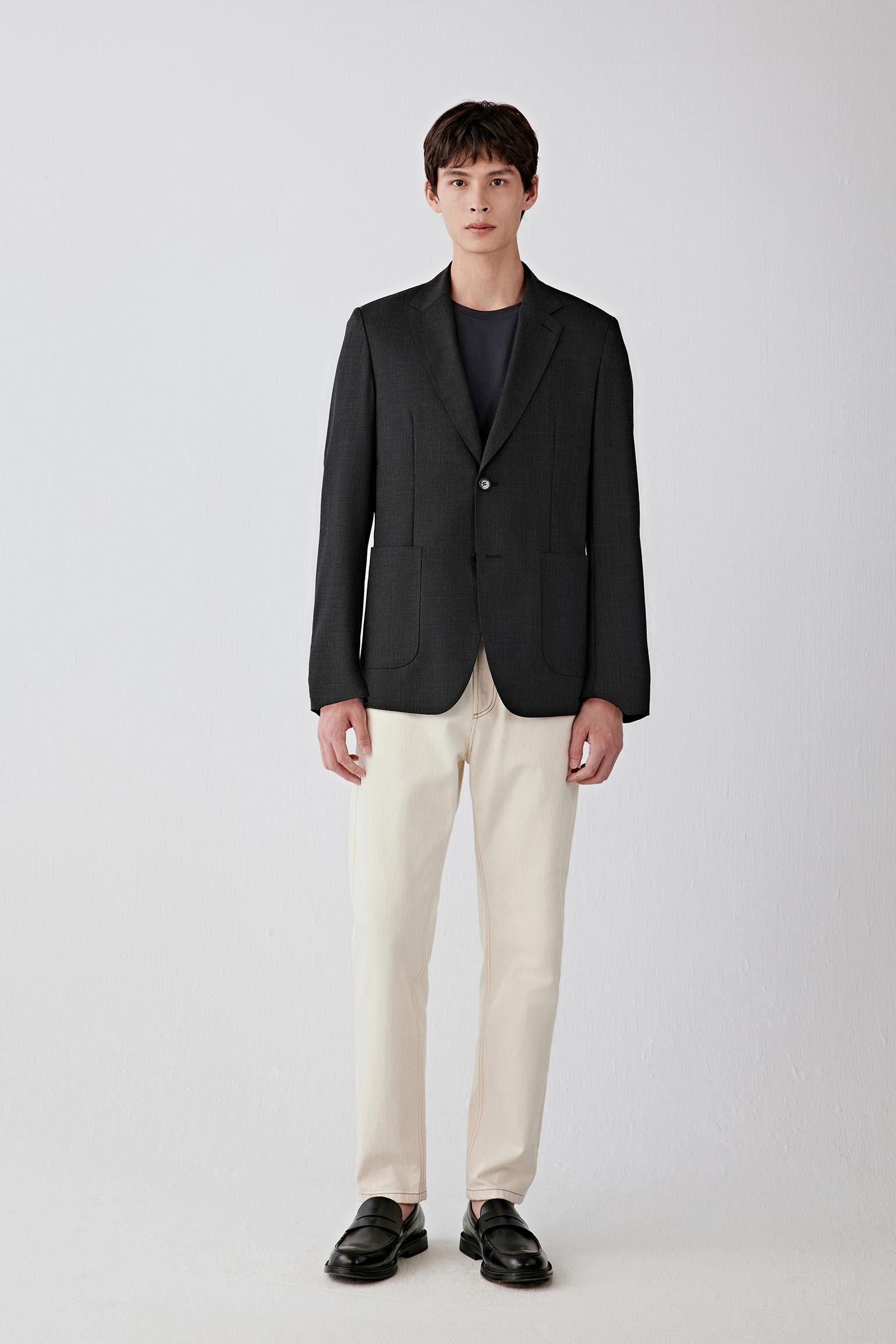 Full-length front view highlighting the single-breasted closure, straight silhouette and contrast between the dark jacket and light trousers, with a balanced, slightly fitted cut through the torso.