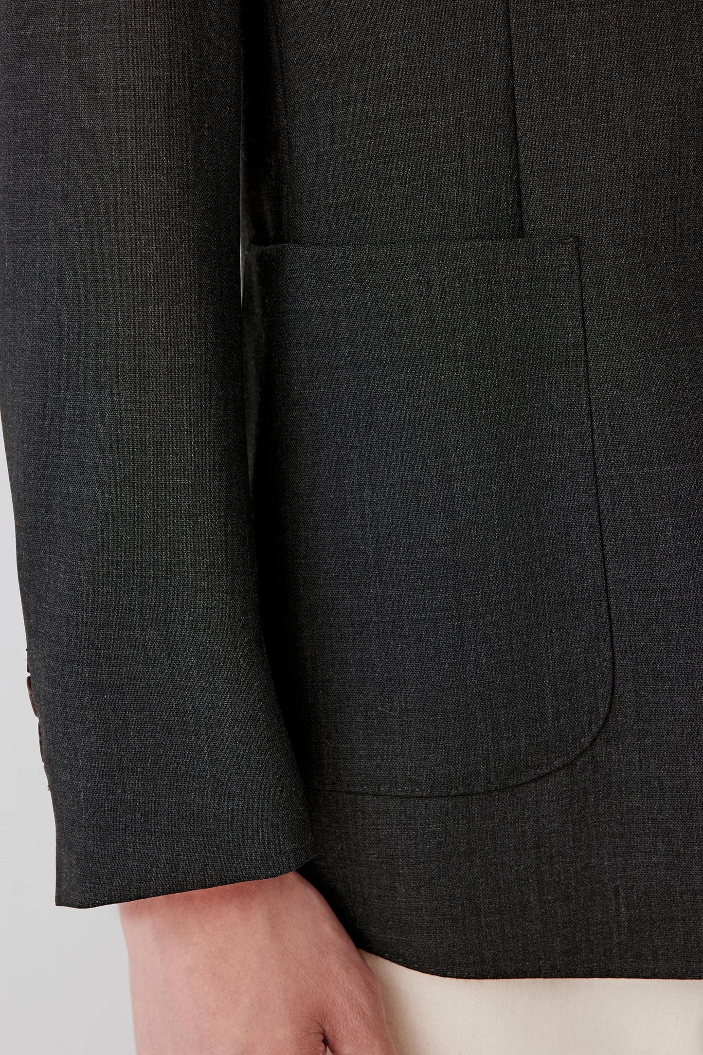 Detail of the sleeve and cuff, highlighting the clean finishing, straight sleeve line and structured fabric hand.