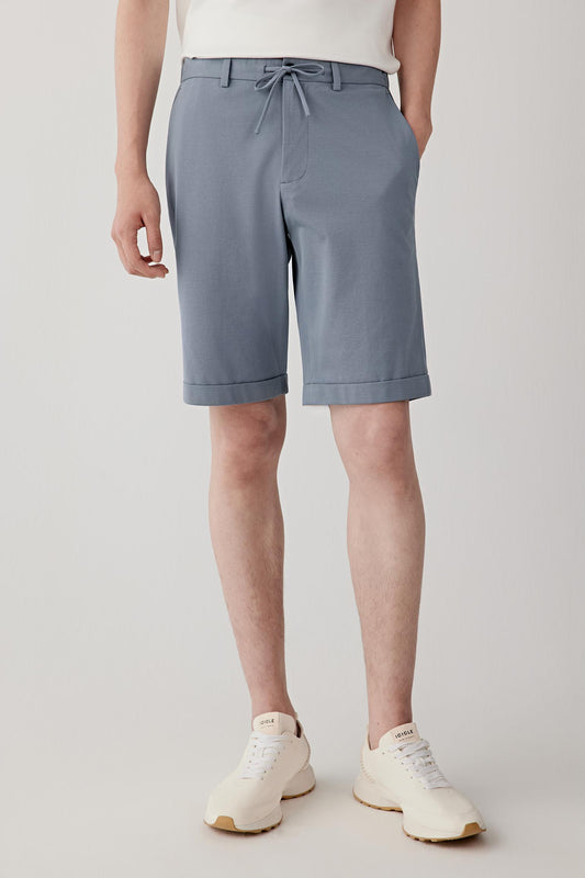 Mid-length front view showing the relaxed silhouette, drawstring waistband and turned-up hems. The shorts fall with ease through the leg while maintaining a lightly structured shape suited to warm-weather wear.