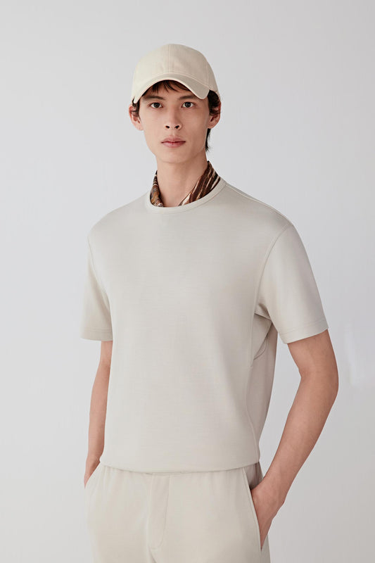 Front view of a beige Ponte de Roma wool T-shirt with a structured yet soft silhouette and short sleeves.