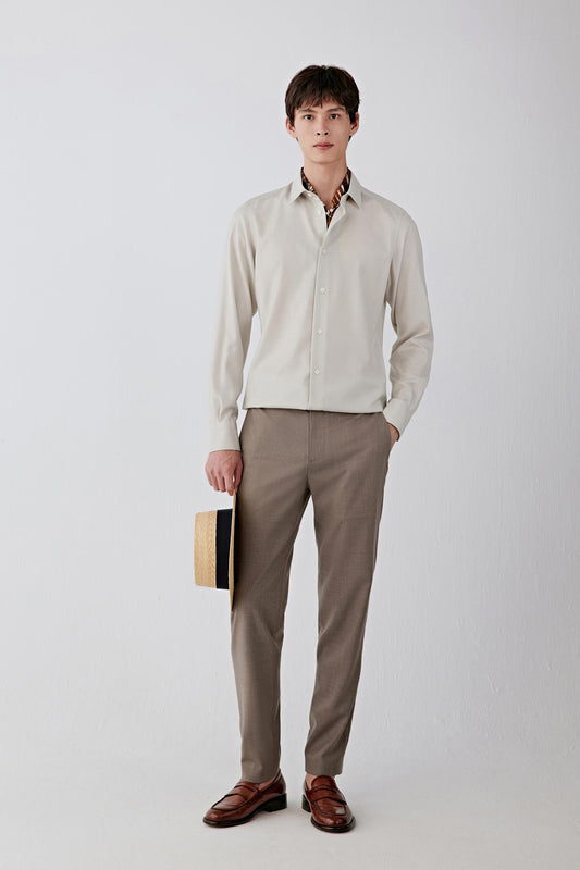 Full-length front view of a wool panama shirt in a soft cream shade, styled with brown trousers.