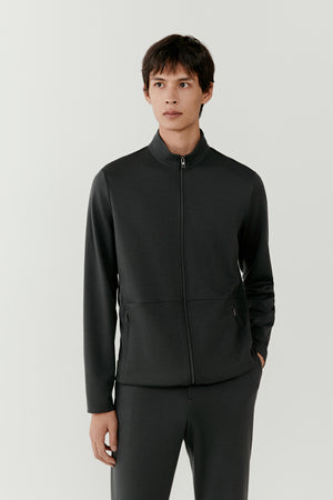 Man wearing an anthracite grey wool zip jacket with slim straight fit, portrait front view highlighting the stand collar and tonal zip closure.